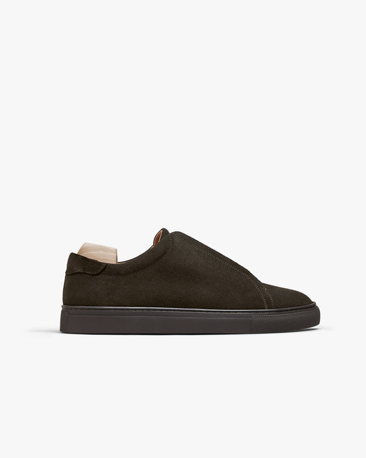 A side profile of the Alnö – Dark Brown Suede sneaker, showing its slip-on silhouette and tonal rubber sole.