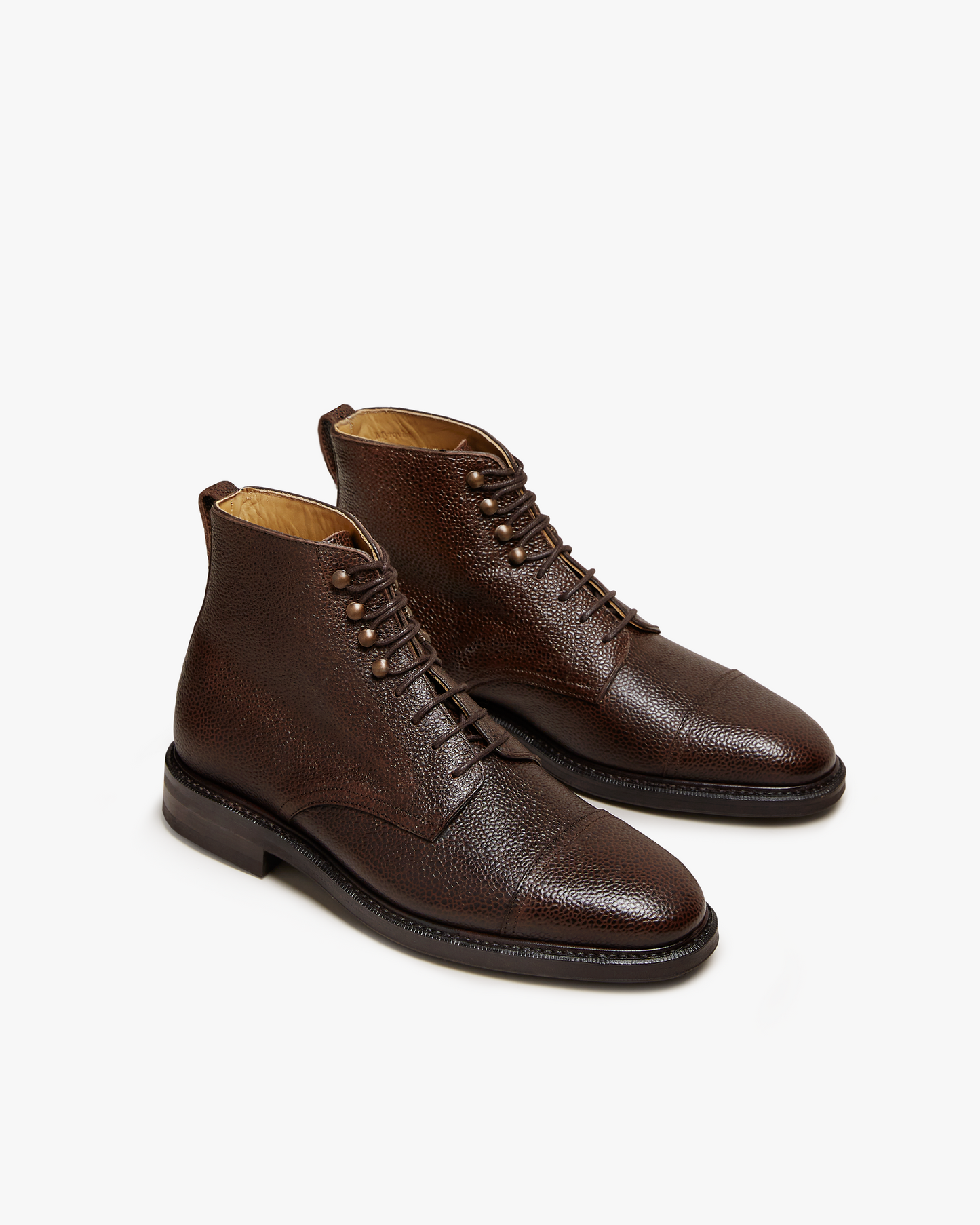 A three-quarter studio view of the Abisko – Dark Brown Country Calf jumper boots, highlighting the textured leather.