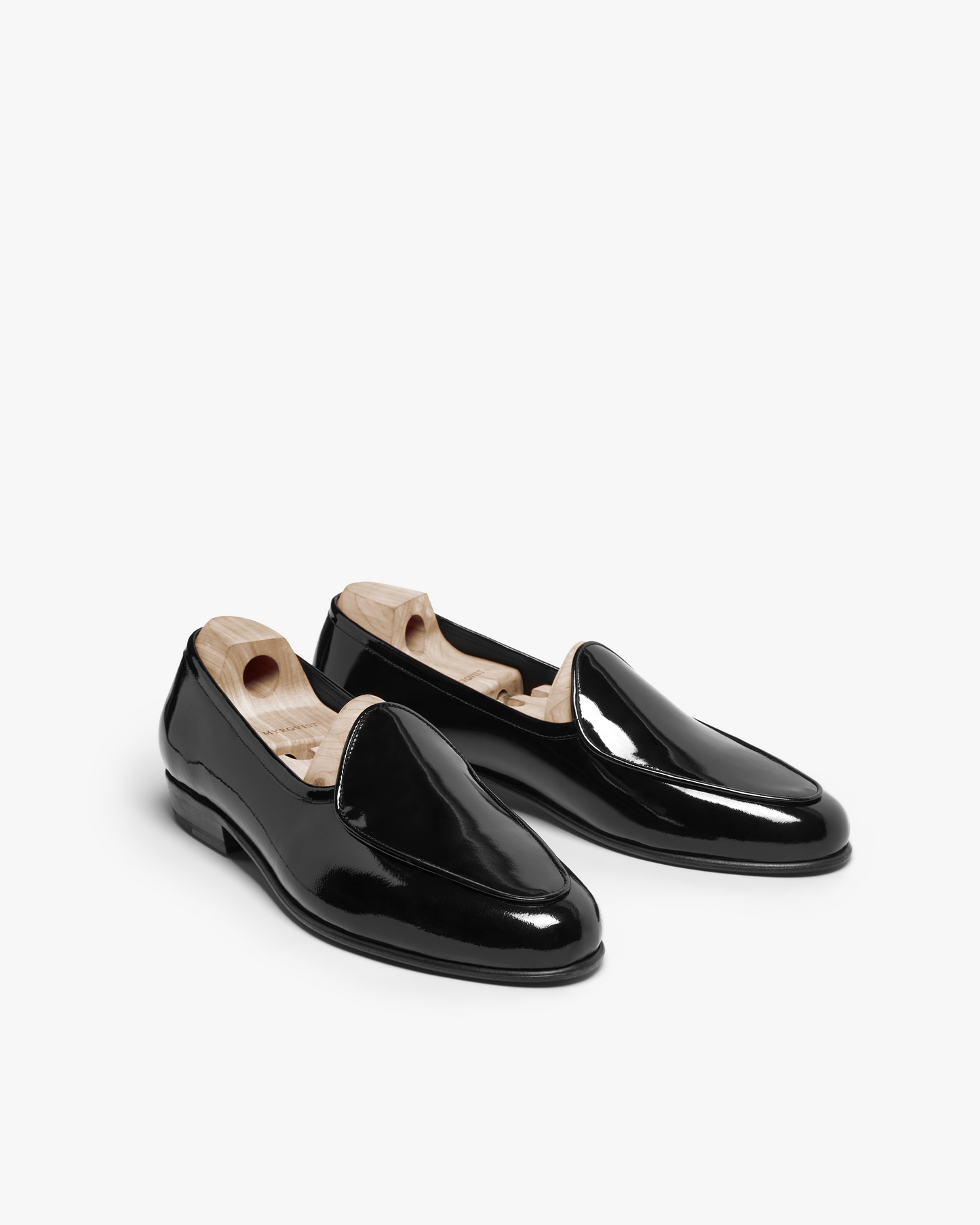 A pair of Ängby – Black Patent Leather loafers with wooden shoe trees, shown on a white background.