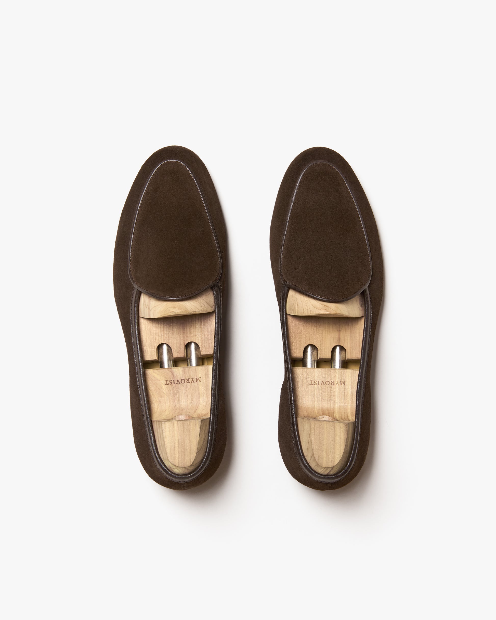 Top-down view of Ängby – Dark Brown Suede loafers with wooden shoe trees against a clean white background.