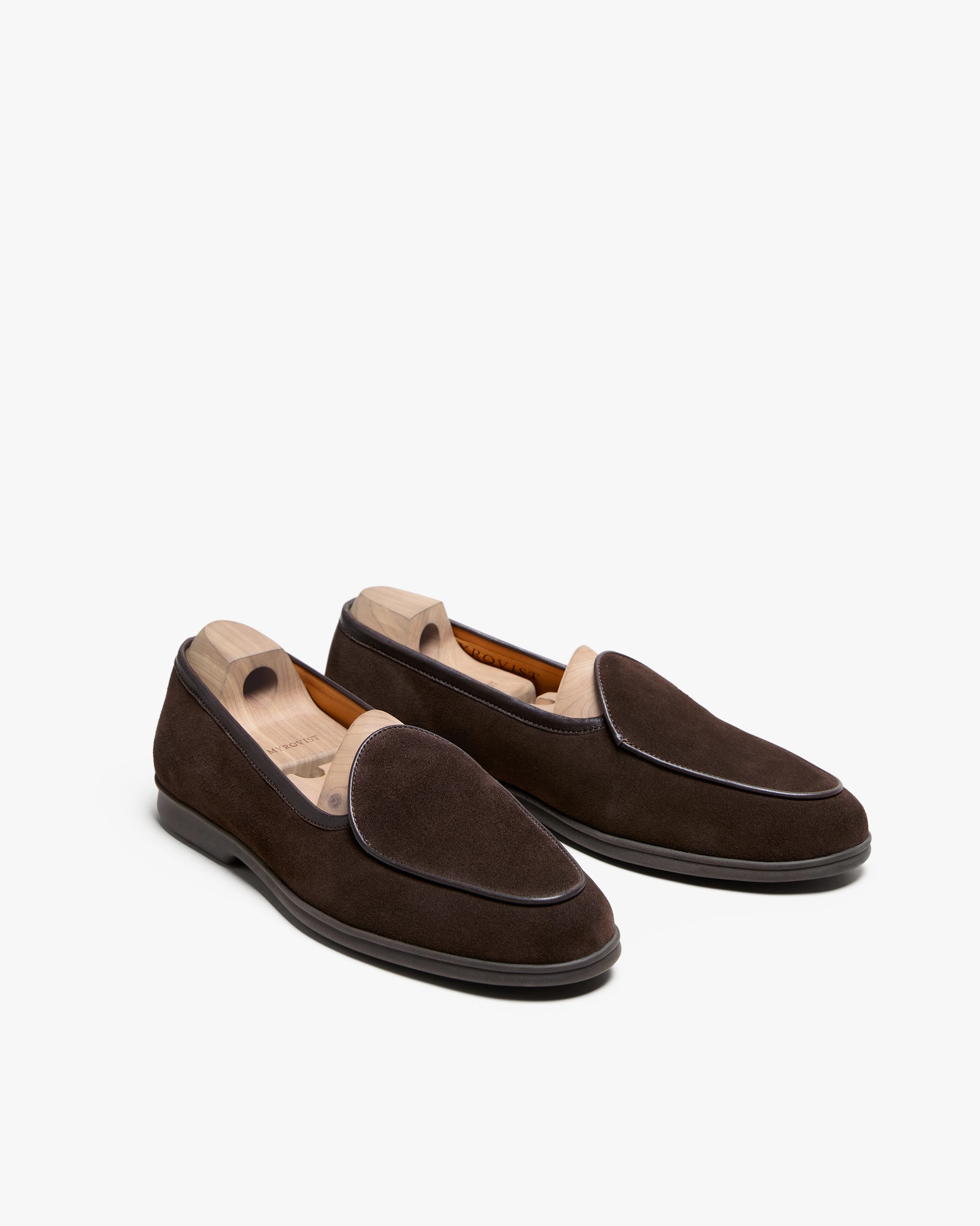 A pair of Ängby Walker – Dark Brown Suede loafers with wooden shoe trees, shown against a white background.