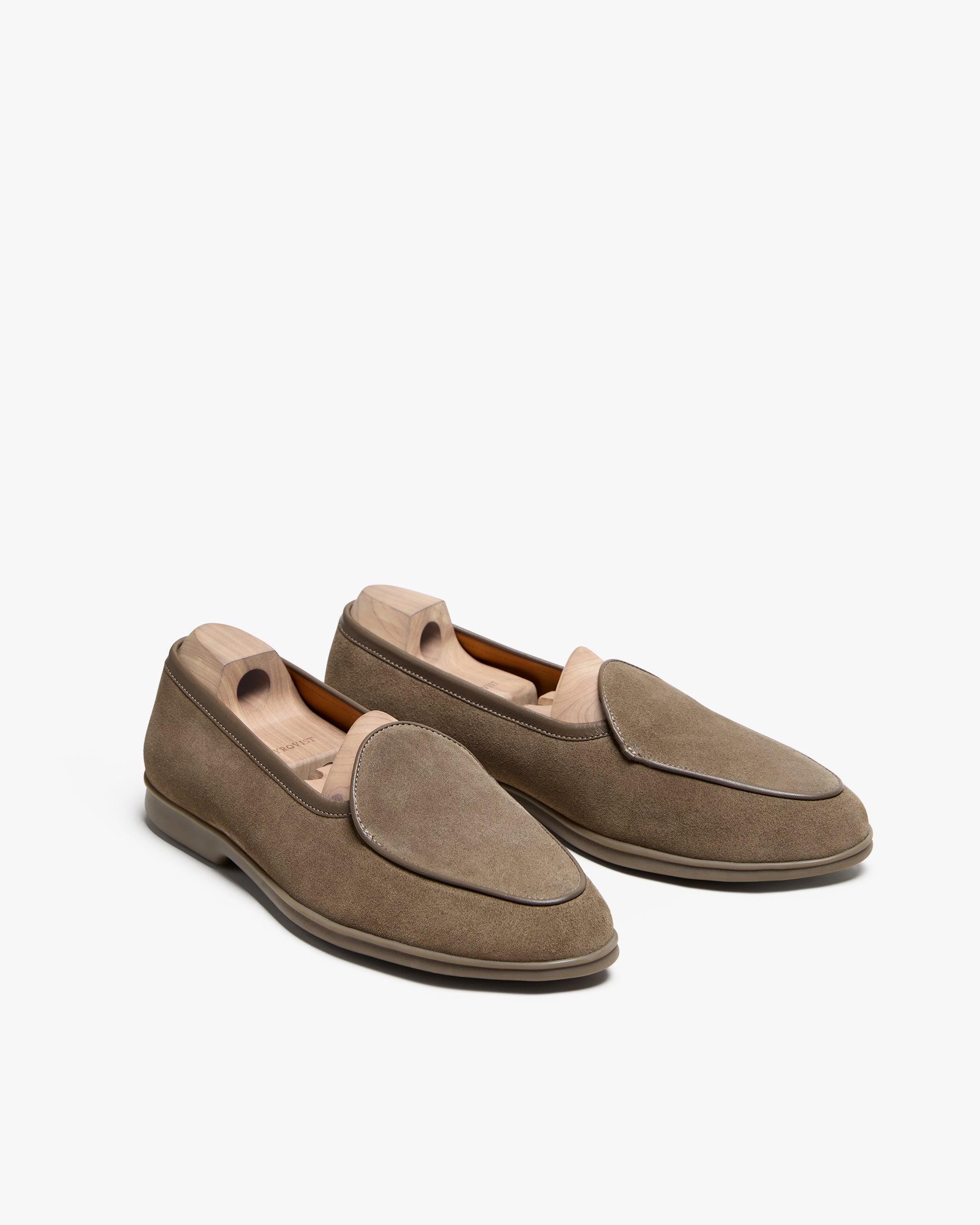 A pair of Ängby Walker – Taupe Suede loafers presented with wooden shoe trees against a white studio background.