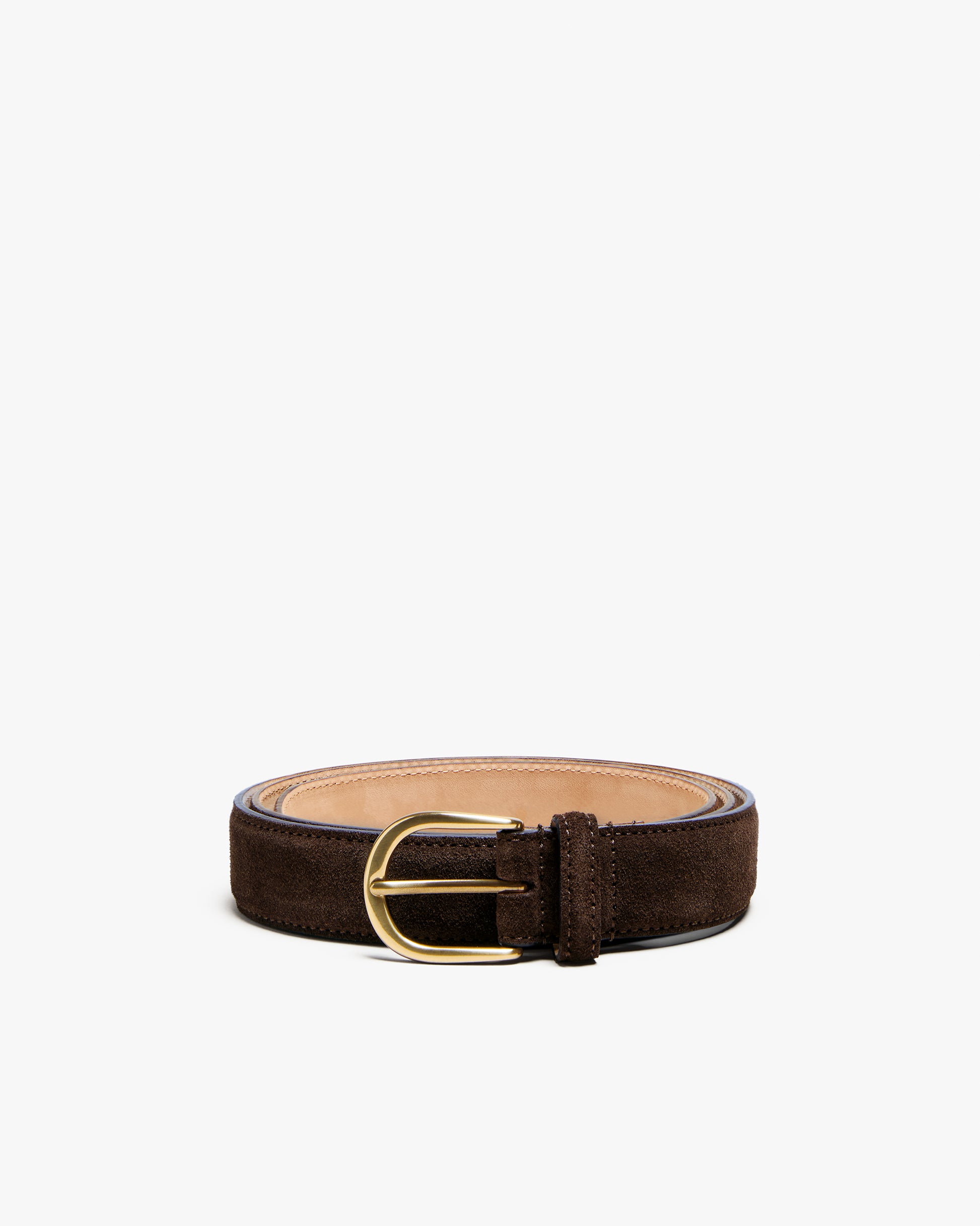 Studio shot of Belt – Dark Brown Suede, coiled up to display its texture and the round, gold-colored buckle.