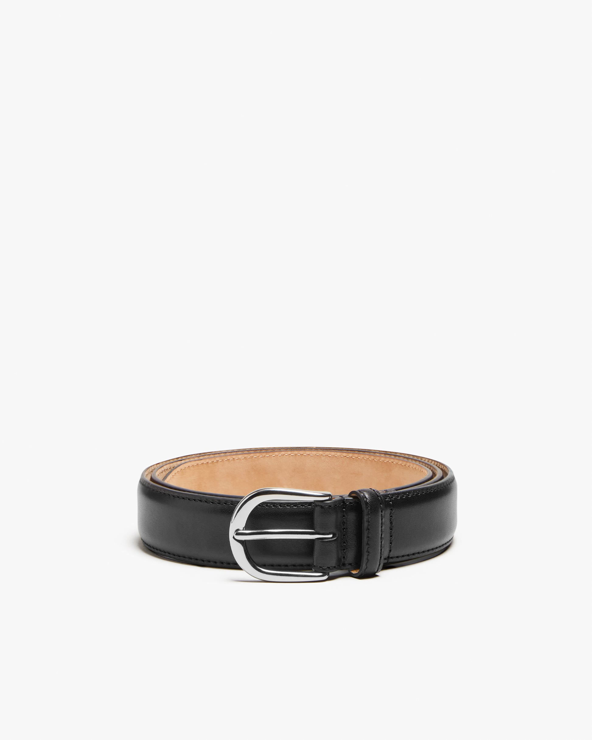 A studio shot of the Belt – Black Leather, coiled to display its smooth texture and 30mm round silver buckle.