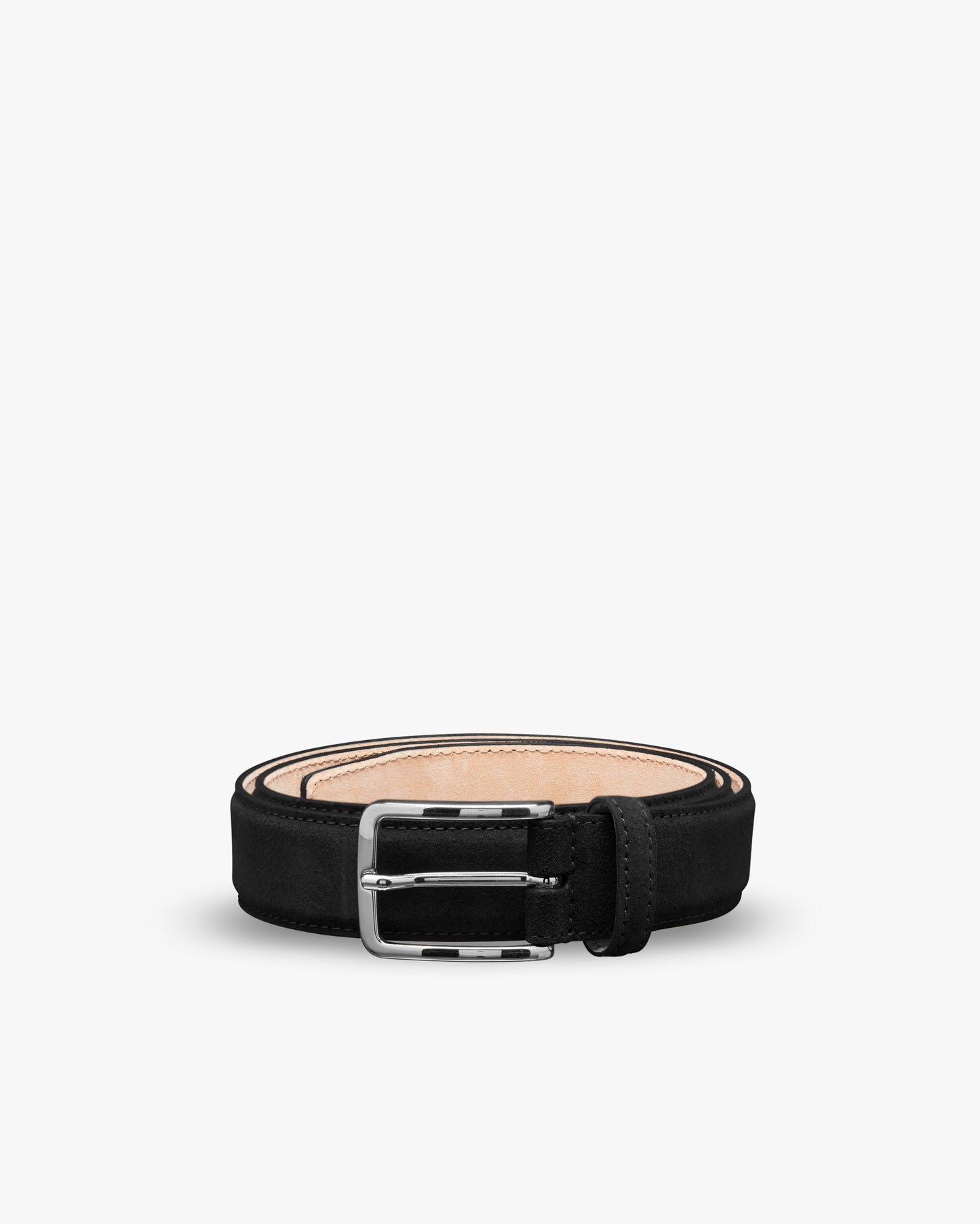 A studio shot of the Belt – Black Suede, coiled to showcase its square silver buckle and fine suede texture.