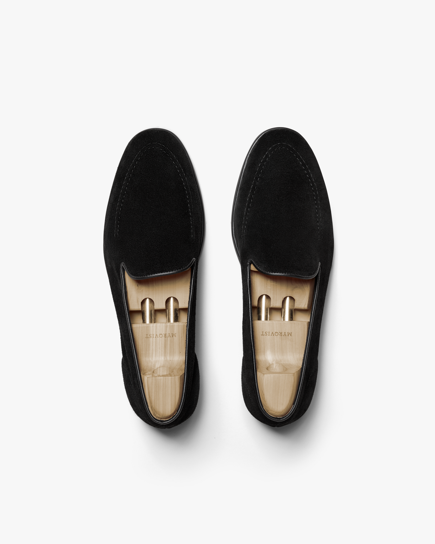 A top-down view of Brännö II – Black Suede loafers, complete with wooden shoe trees.