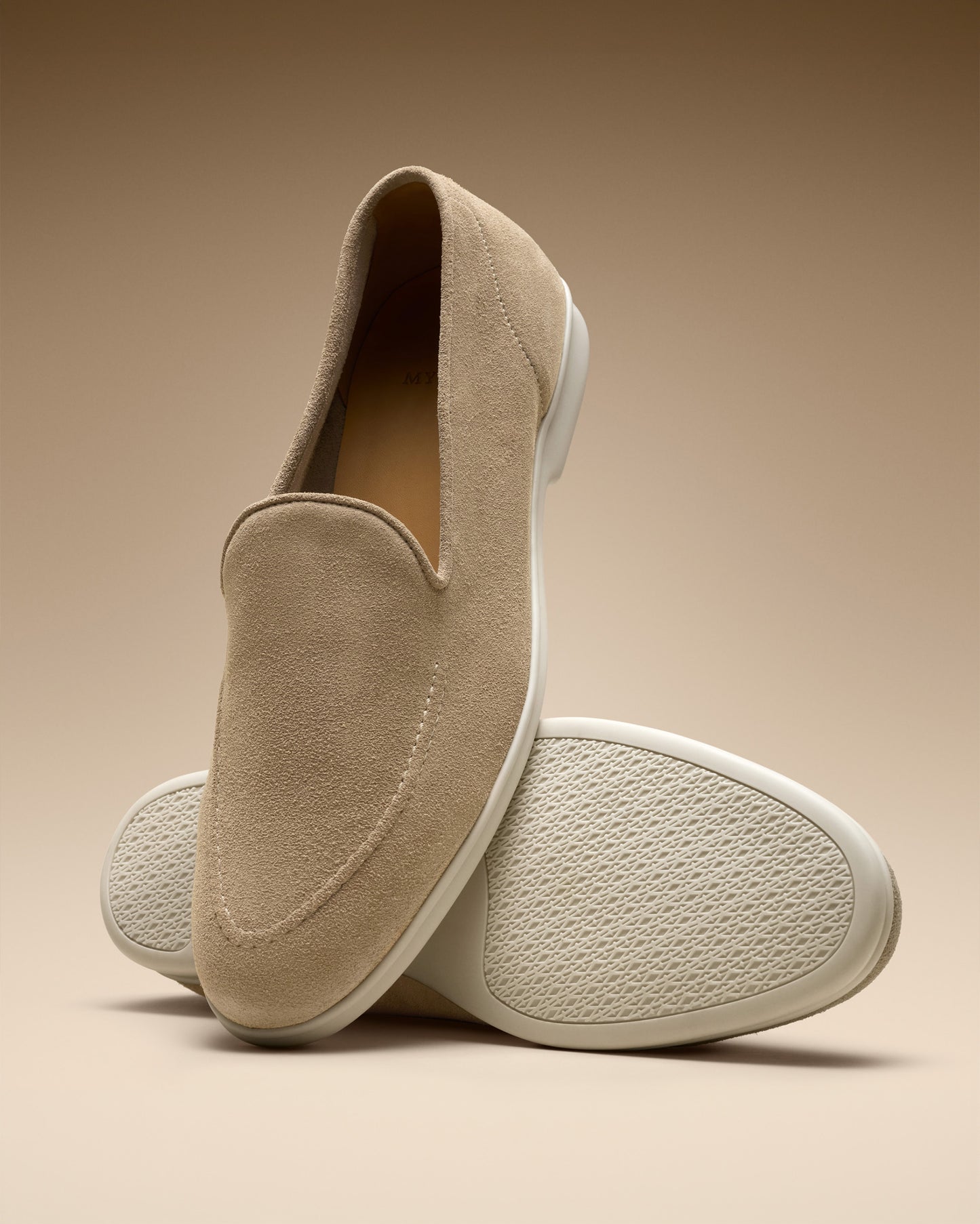 A pair of Brännö II – Sand Suede loafers against a neutral background, with one shoe showing its white rubber sole.