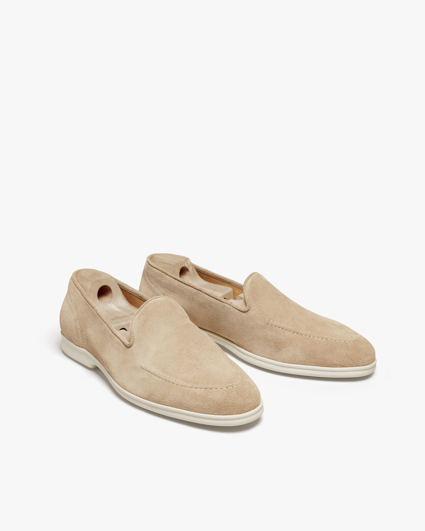A pair of Brännö II – Sand Suede loafers with wooden shoe trees, pictured against a plain white background.
