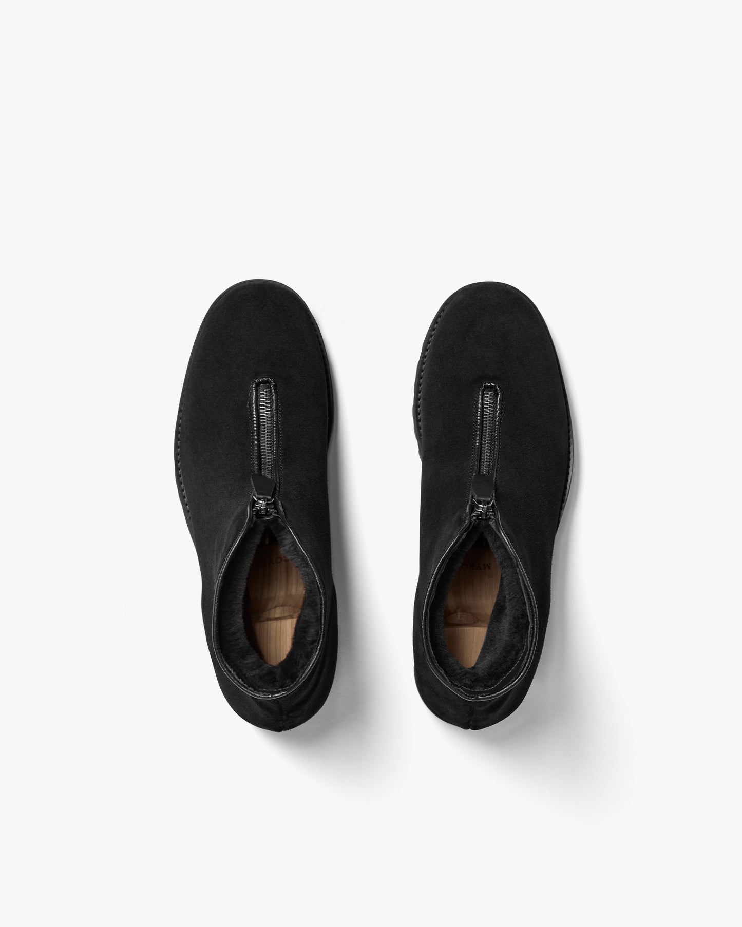 A top-down view of a pair of Funäs – Black Suede boots, highlighting the front zipper and shearling lining.