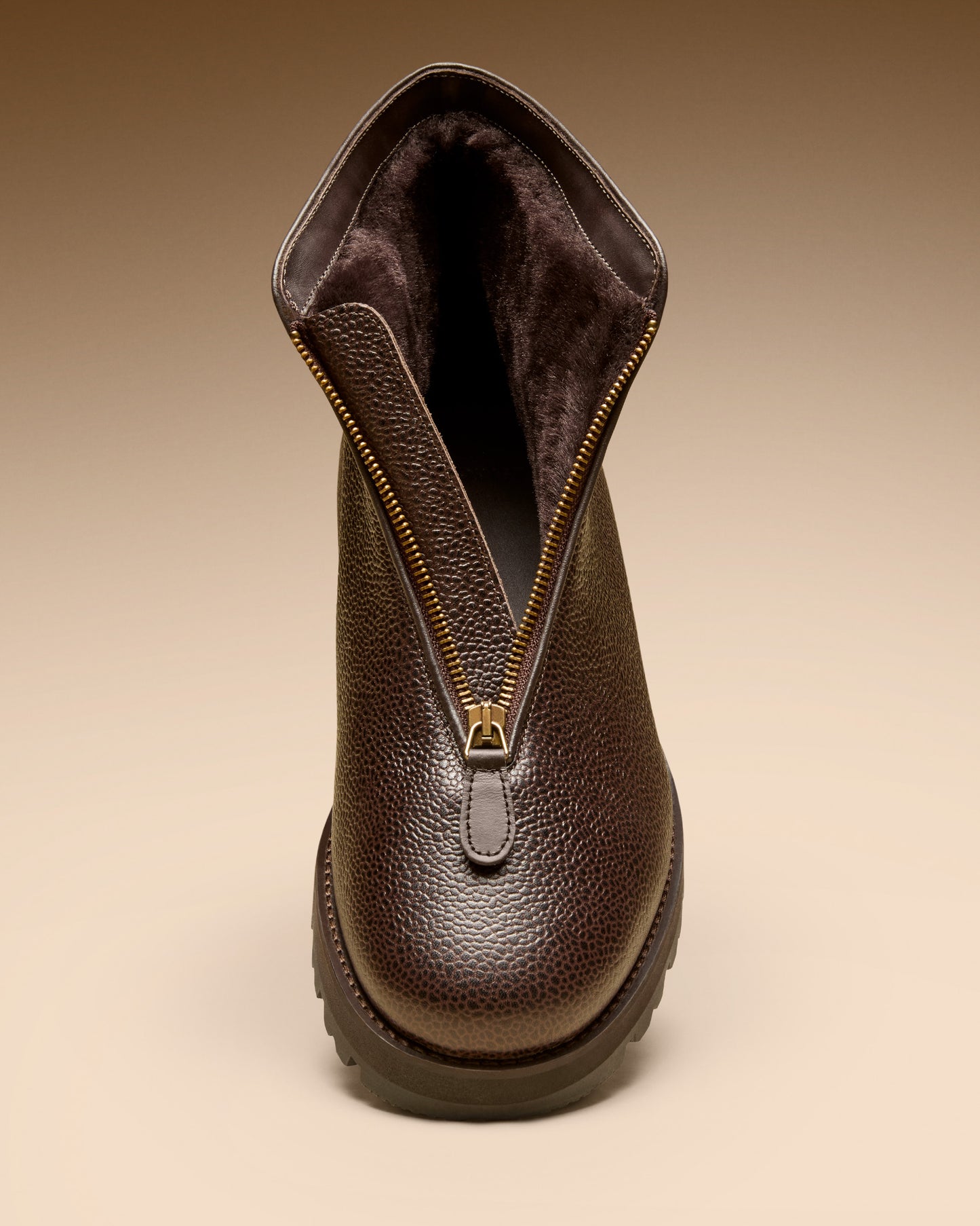Close-up front view of the Funäs boot in dark brown country calf, showing the open zipper and the shearling interior.