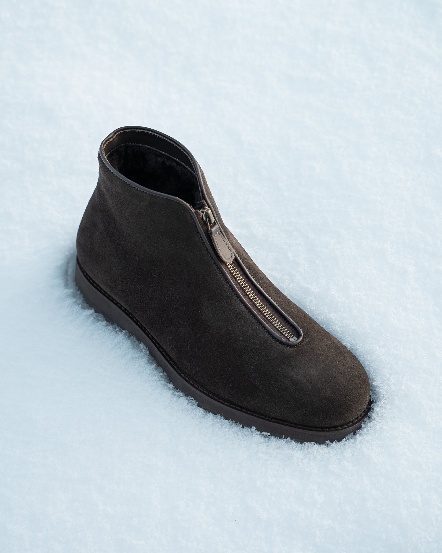 A Funäs – Dark Brown Suede boot, seen from above, resting in a field of fresh snow.