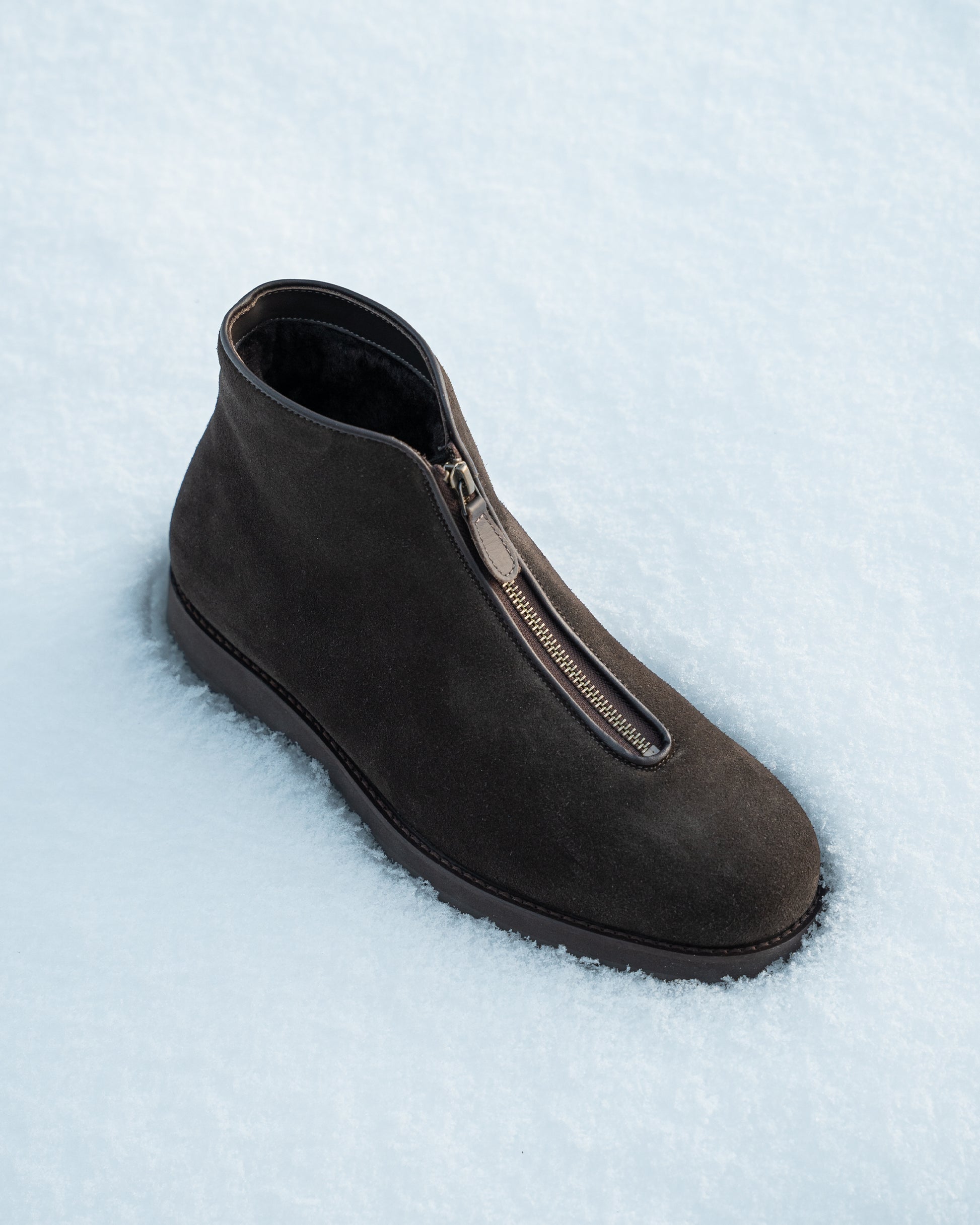 A Funäs – Dark Brown Suede boot, seen from above, resting in a field of fresh snow.