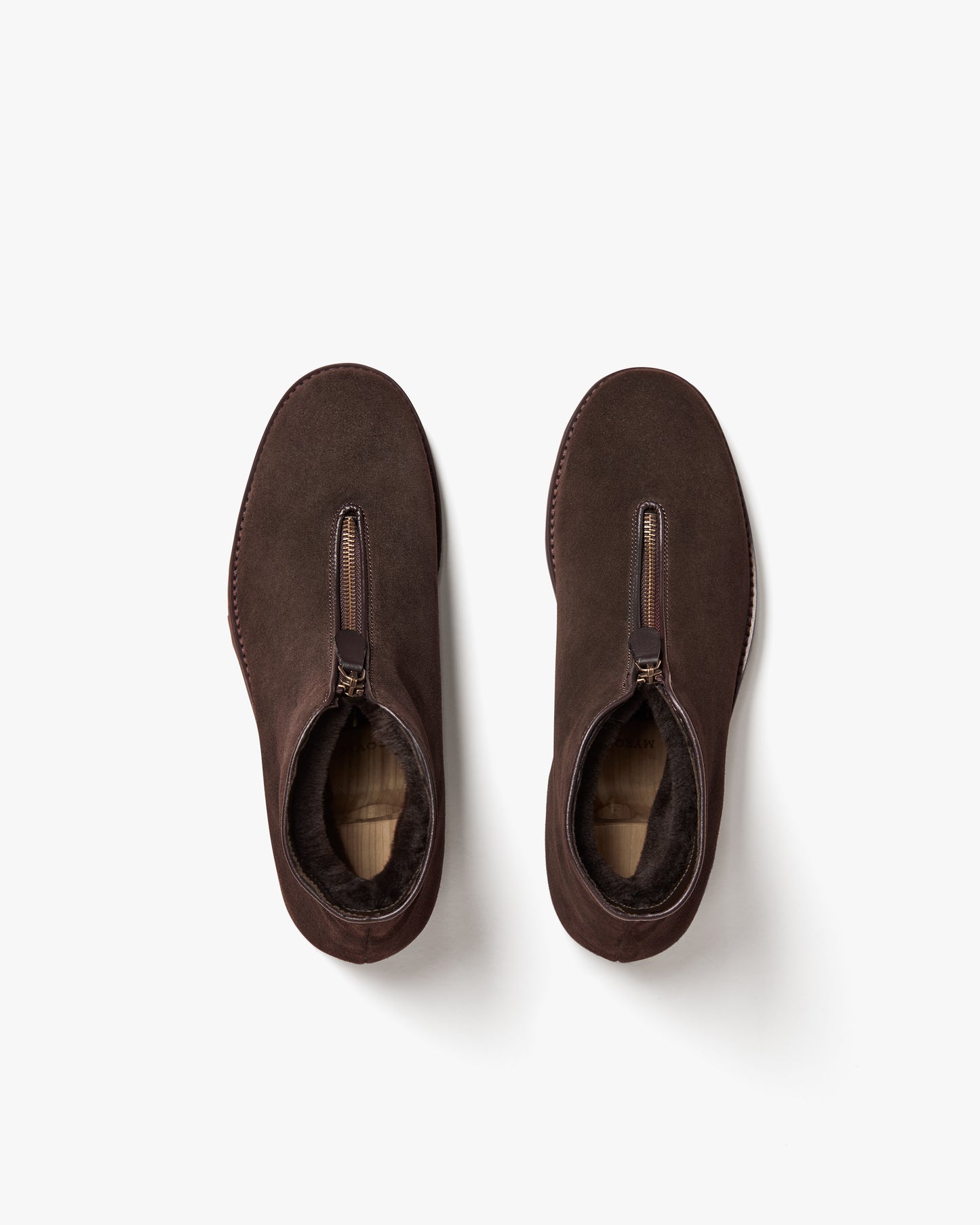 An overhead shot of the Funäs – Dark Brown Suede boots, detailing the front zipper and warm shearling lining.