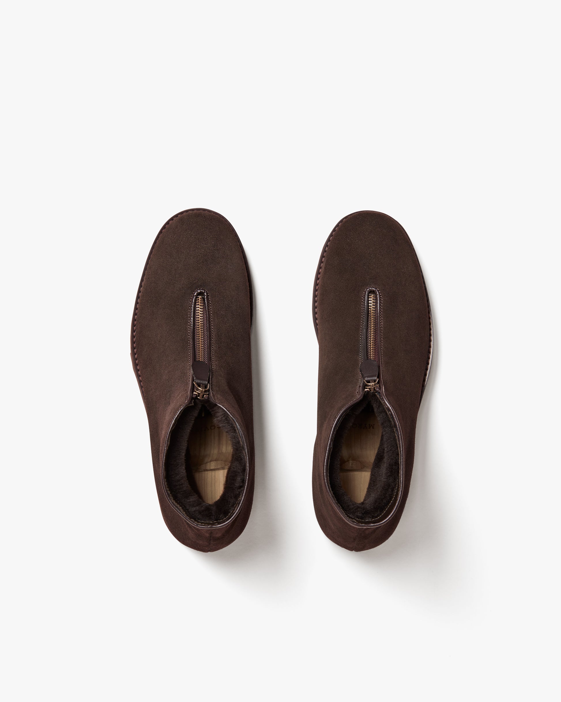 An overhead shot of the Funäs – Dark Brown Suede boots, detailing the front zipper and warm shearling lining.