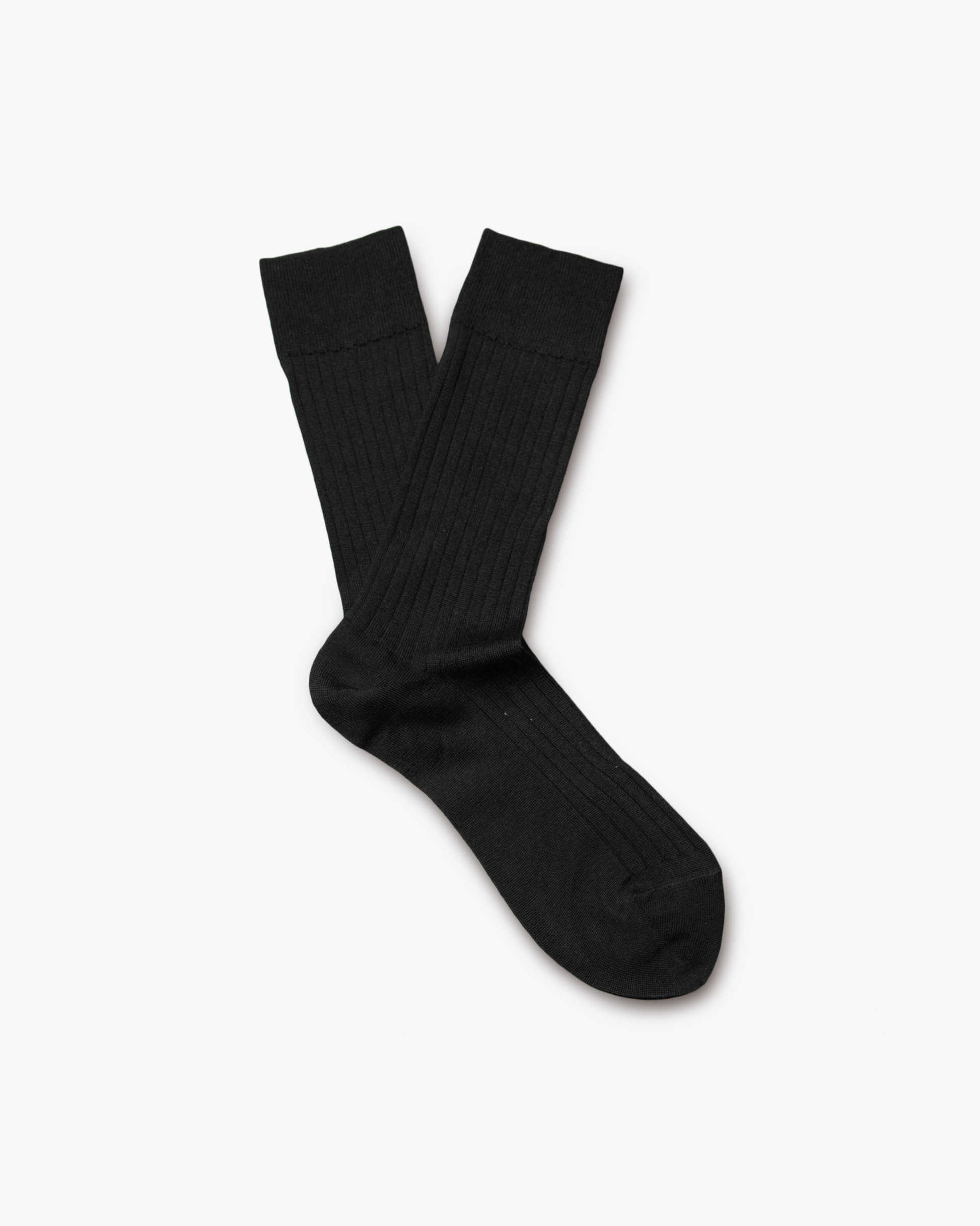 A pair of Ludvig – Merino Wool Socks in black, displayed on a white background to highlight the ribbed texture.