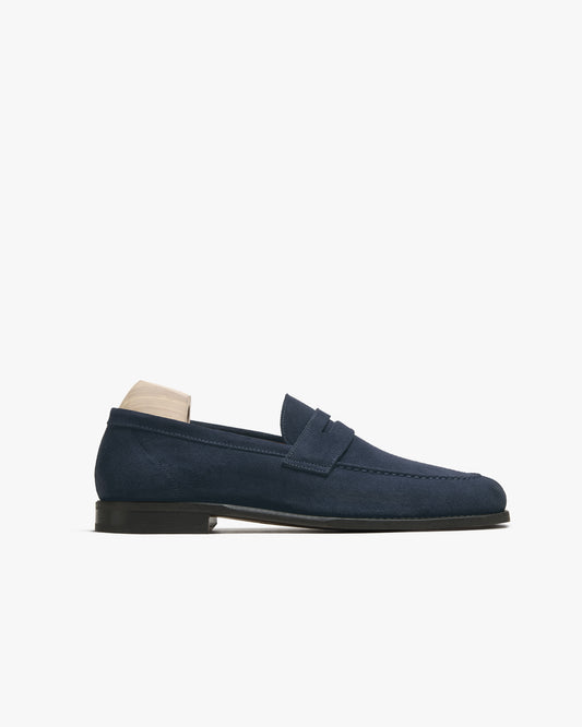A side profile of the Lysekil II – Navy Suede loafer, highlighting its unstructured silhouette and leather sole.