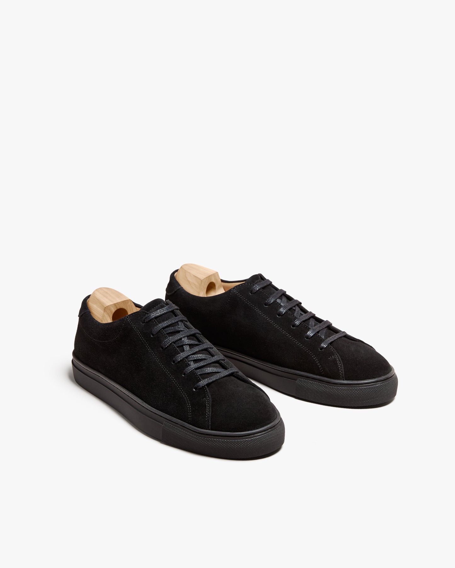 A pair of Oaxen Monochrome II – Black Suede sneakers with shoe trees, shown against a clean white background.