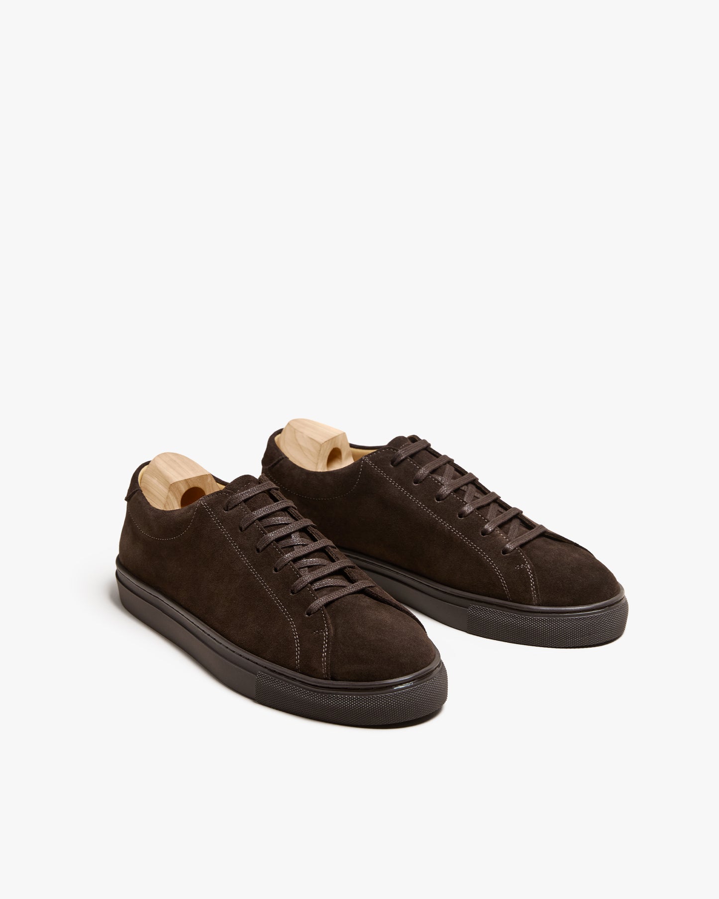 A pair of Oaxen Monochrome II – Dark Brown Suede sneakers with shoe trees, displayed on a white background.