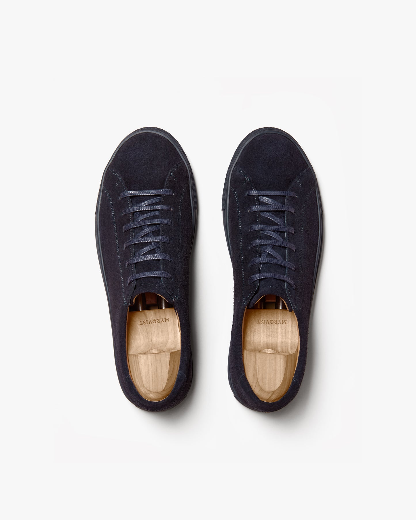 Top-down view of a pair of Oaxen Monochrome II – Navy Suede sneakers with shoe trees, on a white background.