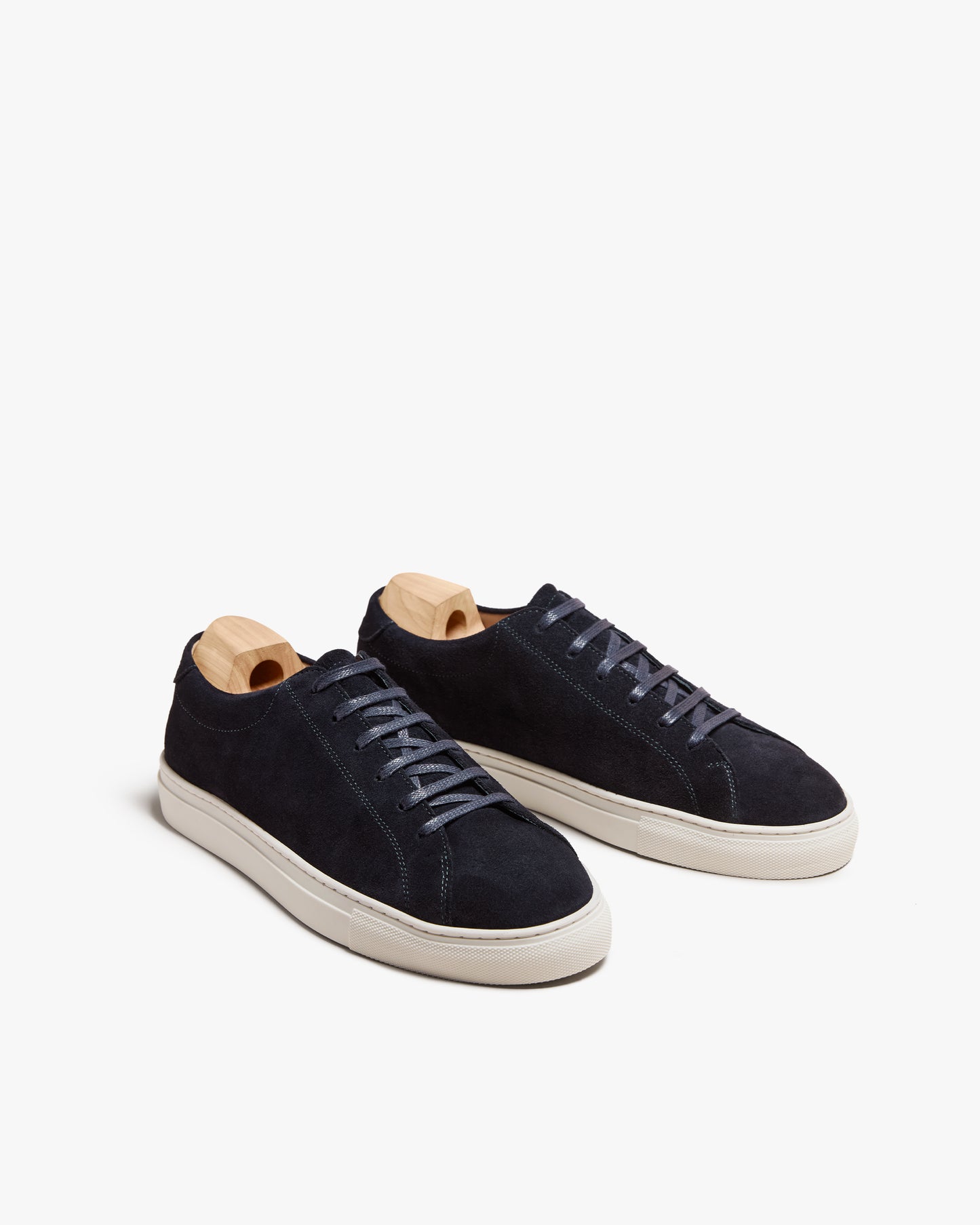 A pair of Oaxen II – Navy Suede sneakers with shoe trees, pictured against a white background.