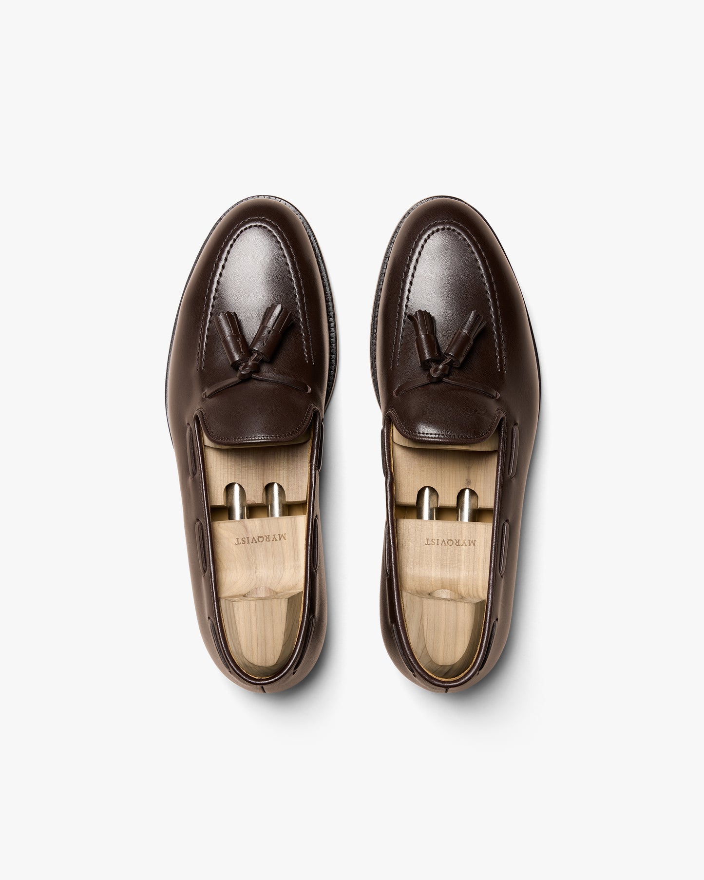 Overhead view of a pair of Mölle II – Dark Brown Calf tassel loafers, shown with wooden shoe trees.