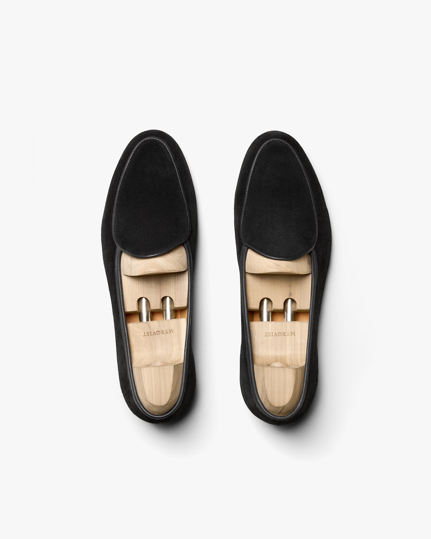 An overhead shot of a pair of Ängby – Black Suede loafers fitted with wooden shoe trees.