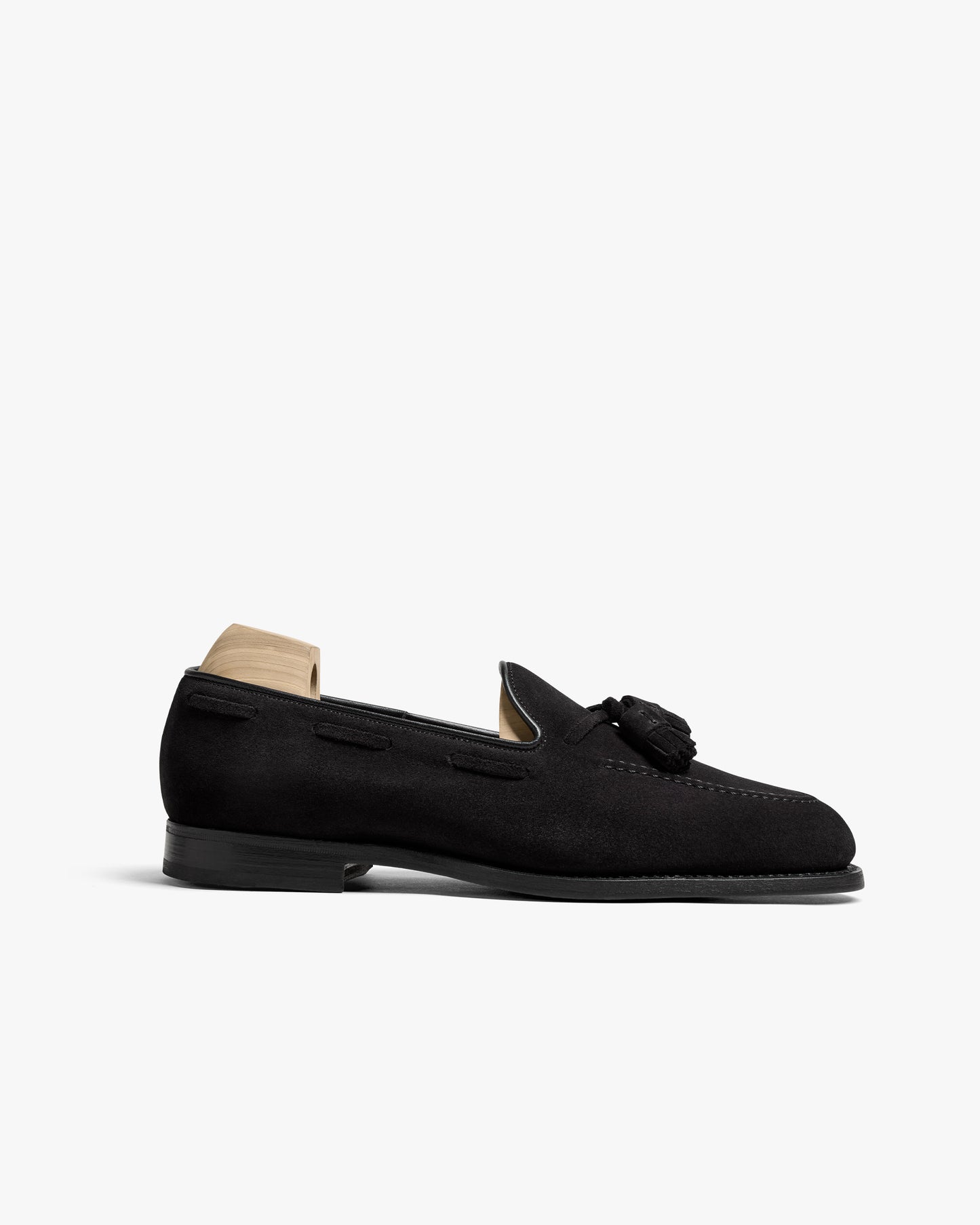 Side profile of the Mölle II – Black Suede tassel loafer, highlighting its elegant silhouette and almond-shaped toe.