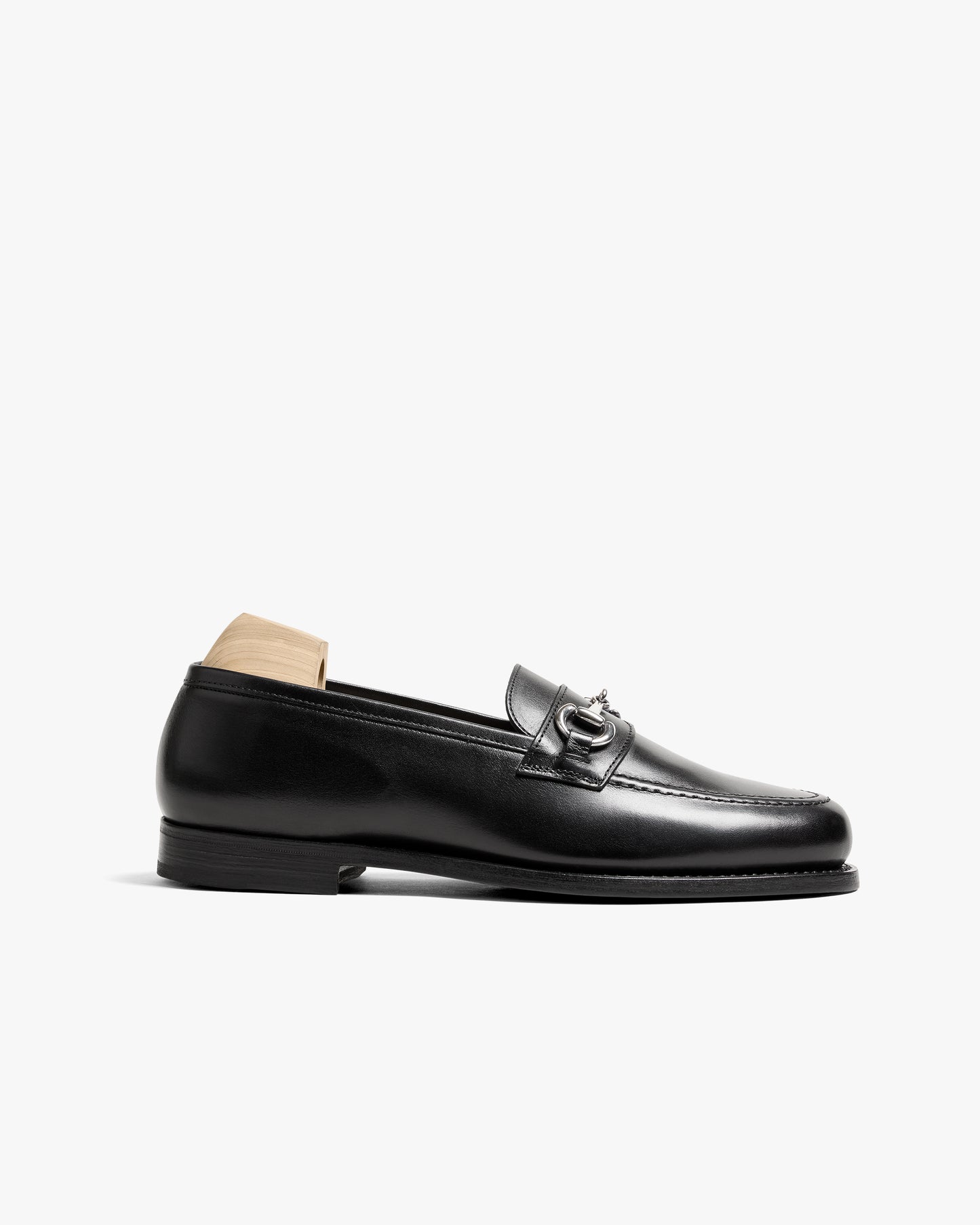 A side profile of Karlberg – Black Calf, a black leather horsebit loafer, showcasing its refined silhouette.