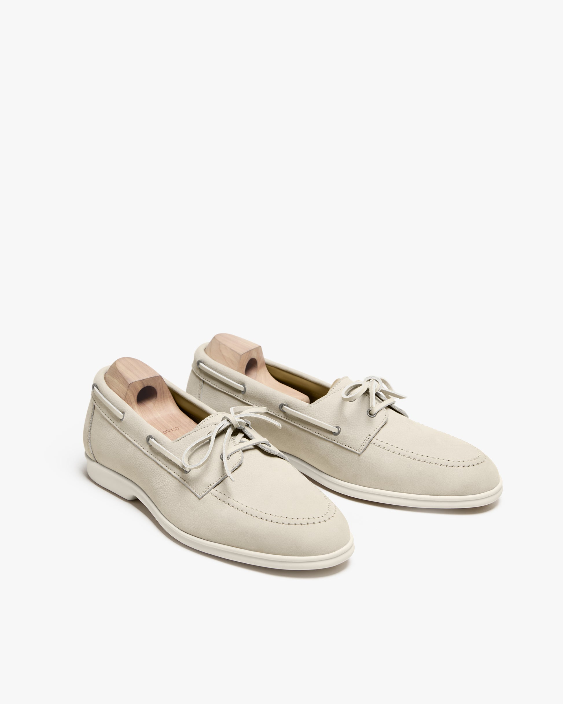 A pair of Sandhamn – Beige Nubuck boat shoes with wooden shoe trees, photographed against a white background.