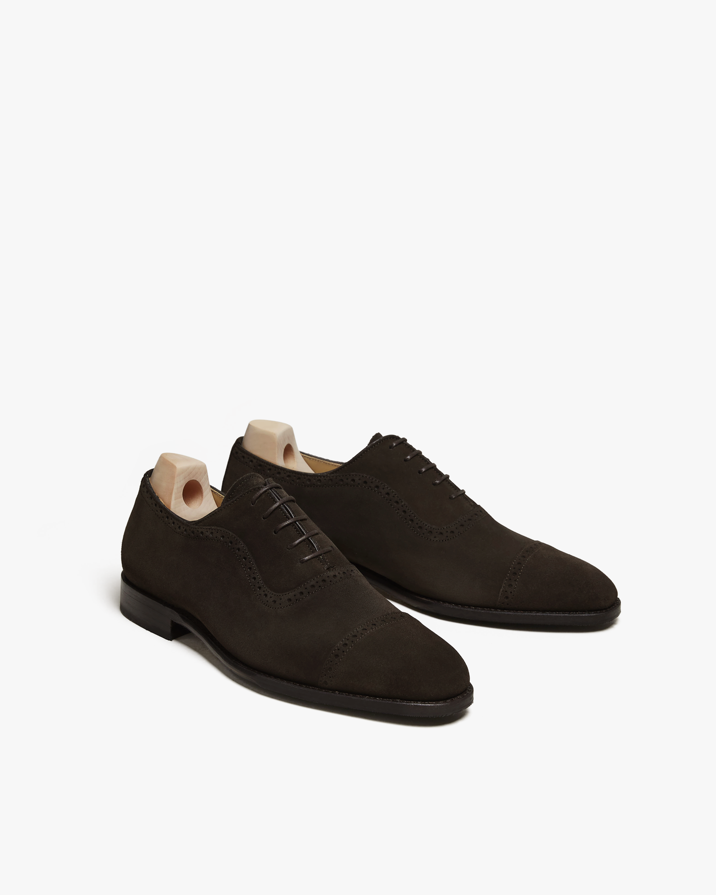 A pair of Skytteholm – Dark Brown Suede oxford shoes with shoe trees, displayed against a white background.