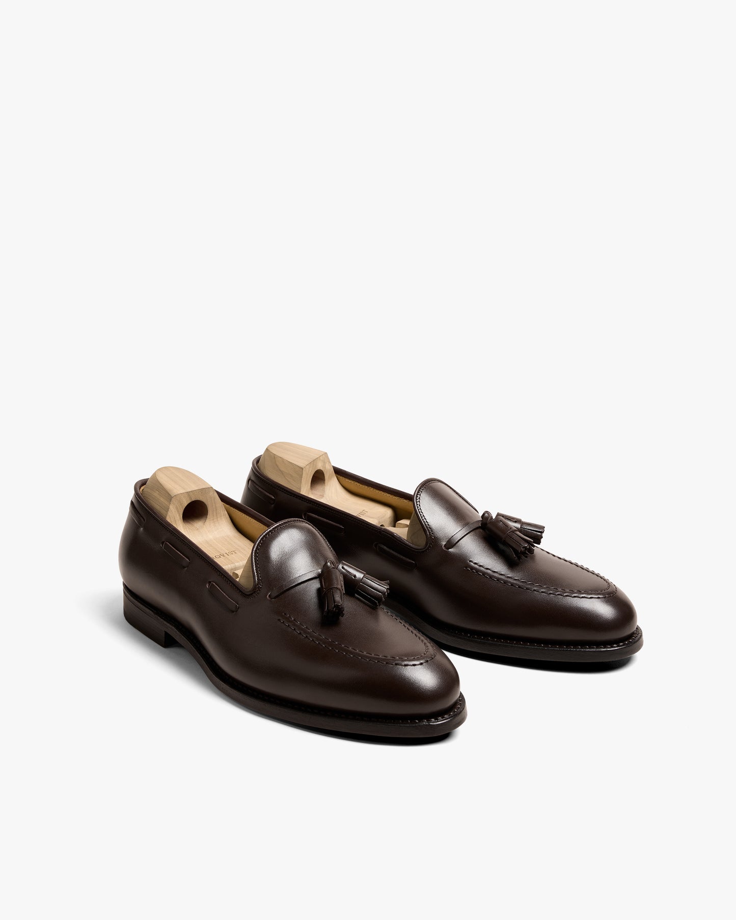 A pair of Mölle II – Dark Brown Calf tassel loafers with shoe trees, shown from an angled perspective on a white background.