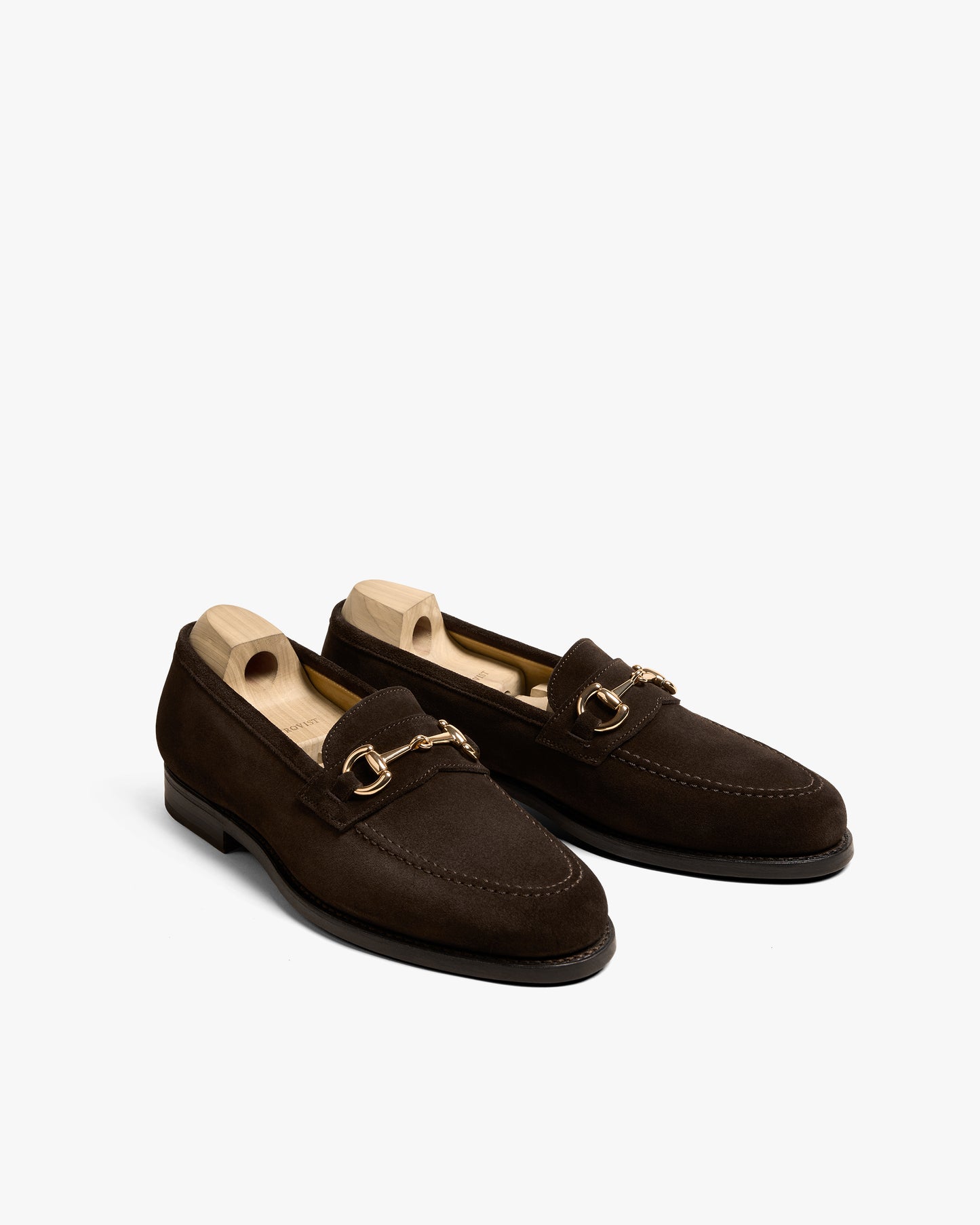 A pair of Karlberg – Dark Brown Suede horsebit loafers with shoe trees, pictured against a white background.
