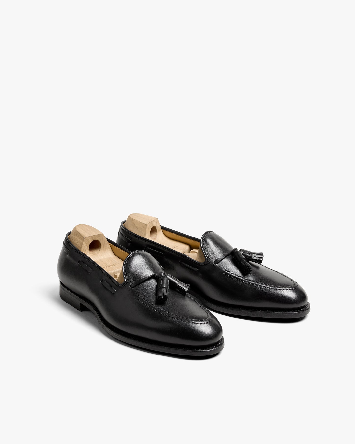 A pair of Mölle II – Black Calf tassel loafers with shoe trees, shown from a three-quarter angle on a white background.
