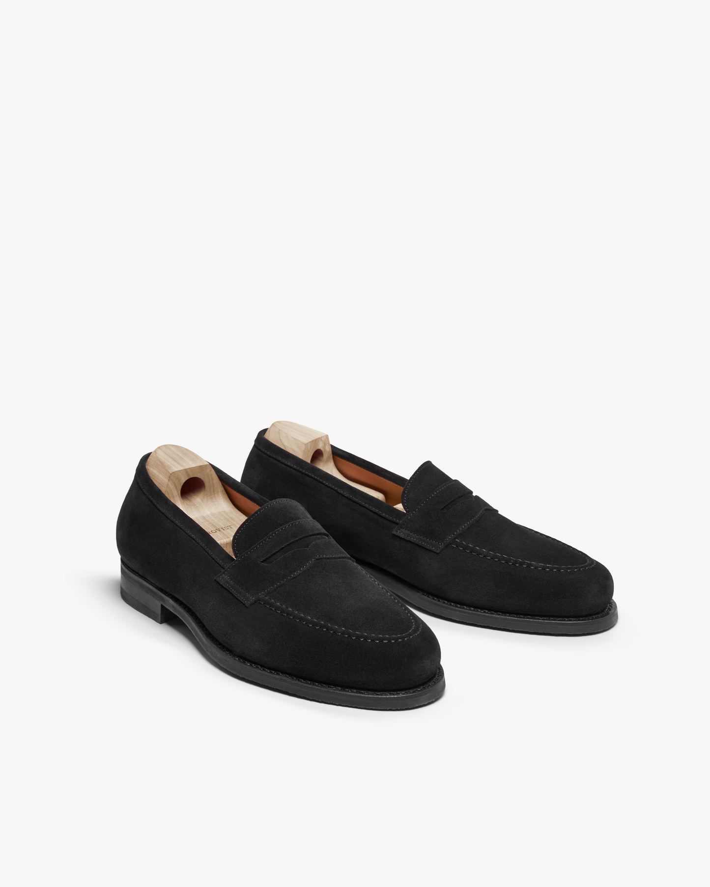 A studio shot of the Stenhammar II – Black Suede loafers, displayed with wooden shoe trees.