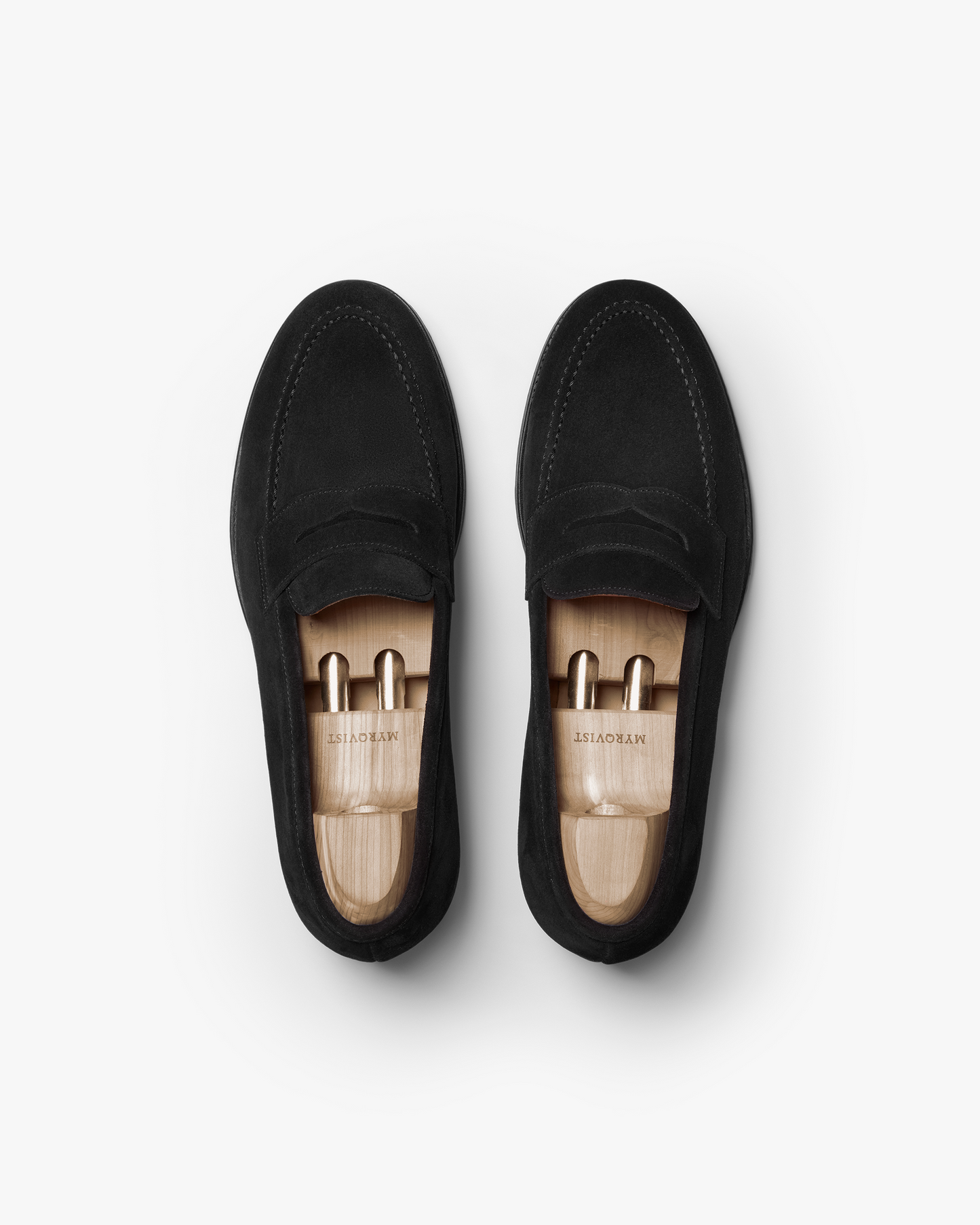 A pair of Stenhammar II – Black Suede loafers with wooden shoe trees, photographed from above against a white background.