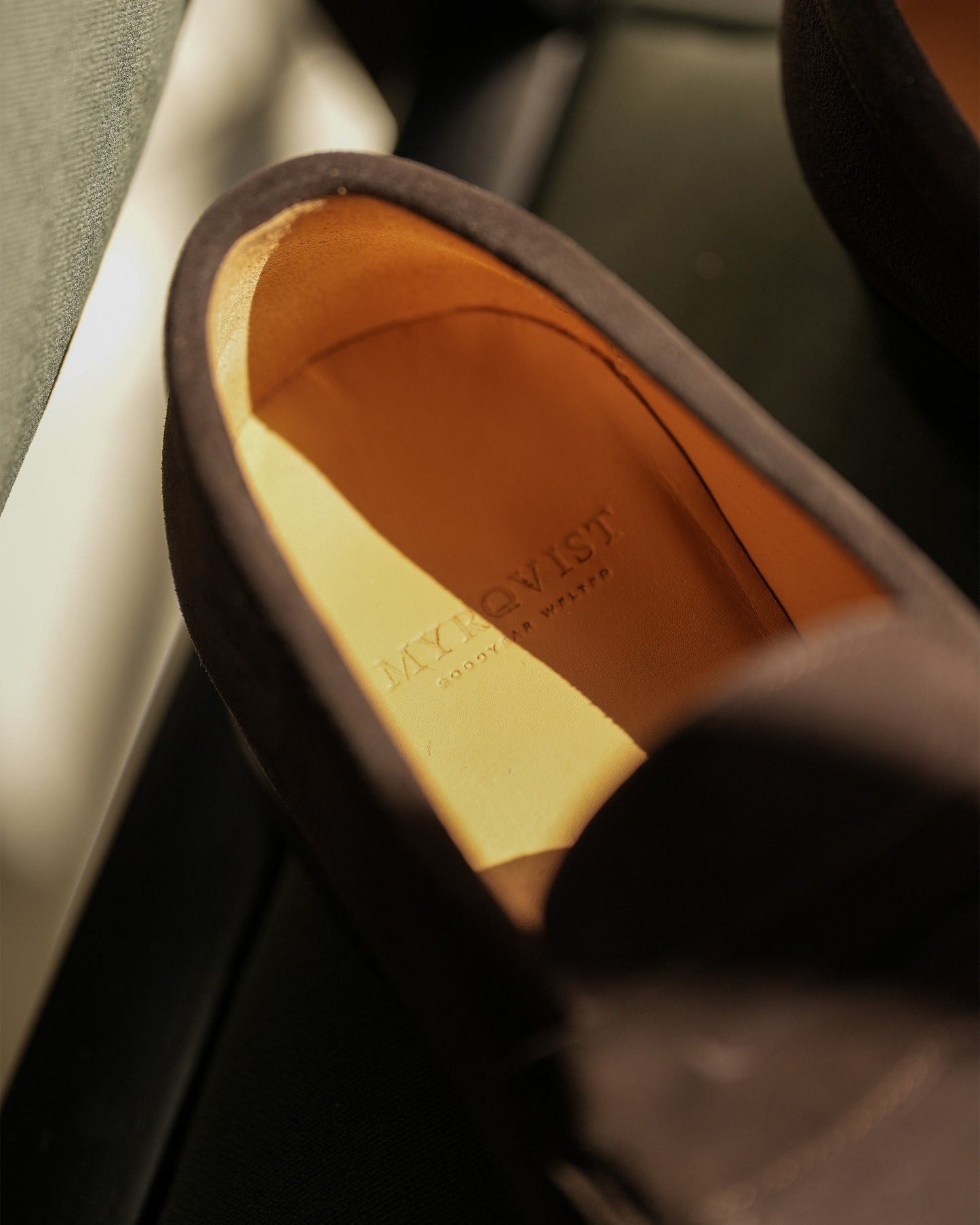 A close-up of the Stenhammar – Dark Brown Suede loafer, detailing the tan leather insole with the embossed Myrqvist logo.
