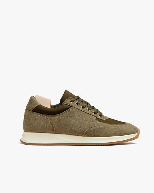 Side profile of the Stensund – Moss Green Suede trainer, showcasing its suede upper, white midsole, and gum rubber outsole.