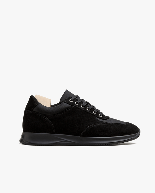 A side profile of the Stensund – Black Suede trainer, detailing the suede and mesh panels and the black rubber sole.