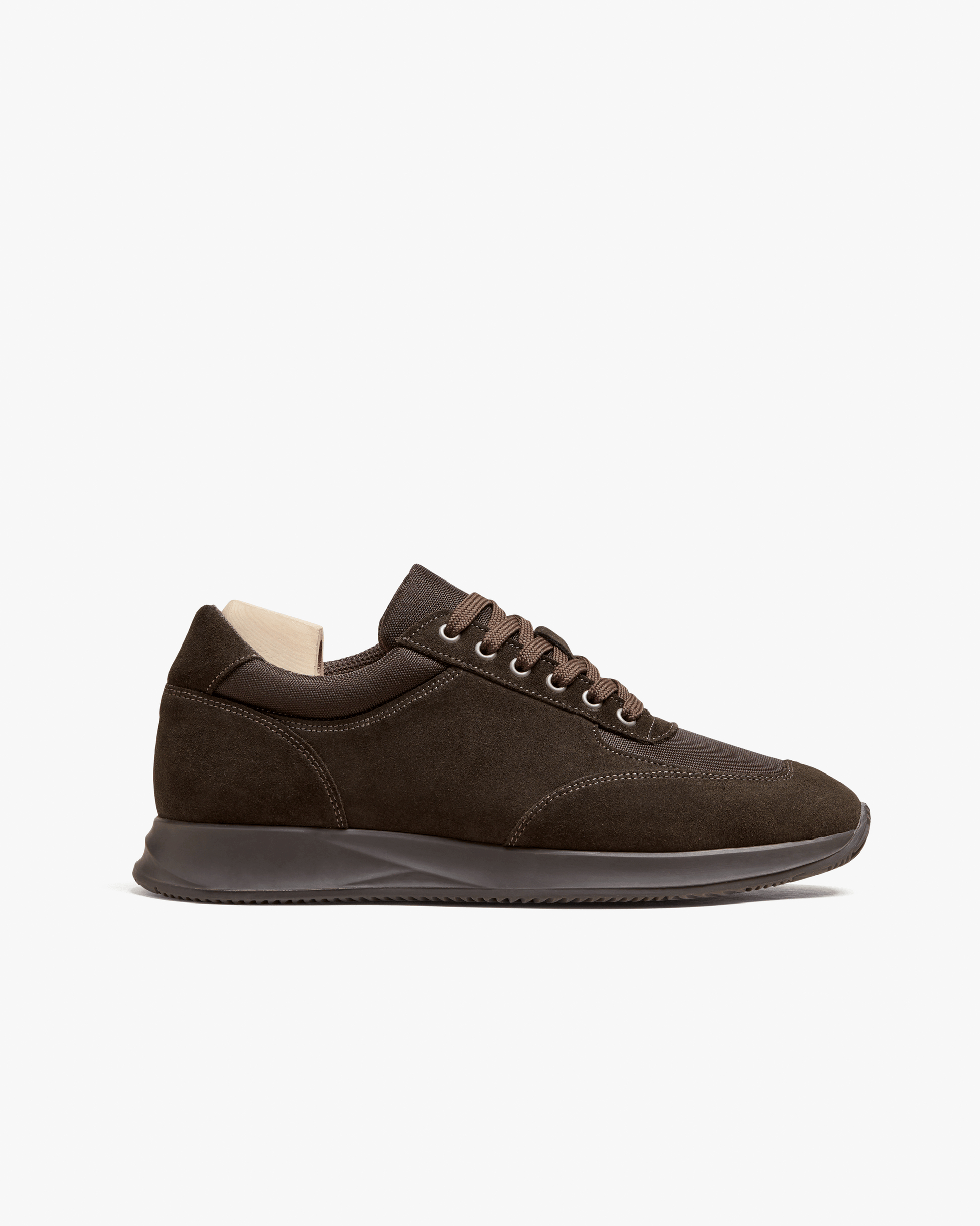 A profile view of the Stensund – Dark Brown Suede sneaker, detailing its suede upper and matching rubber sole.