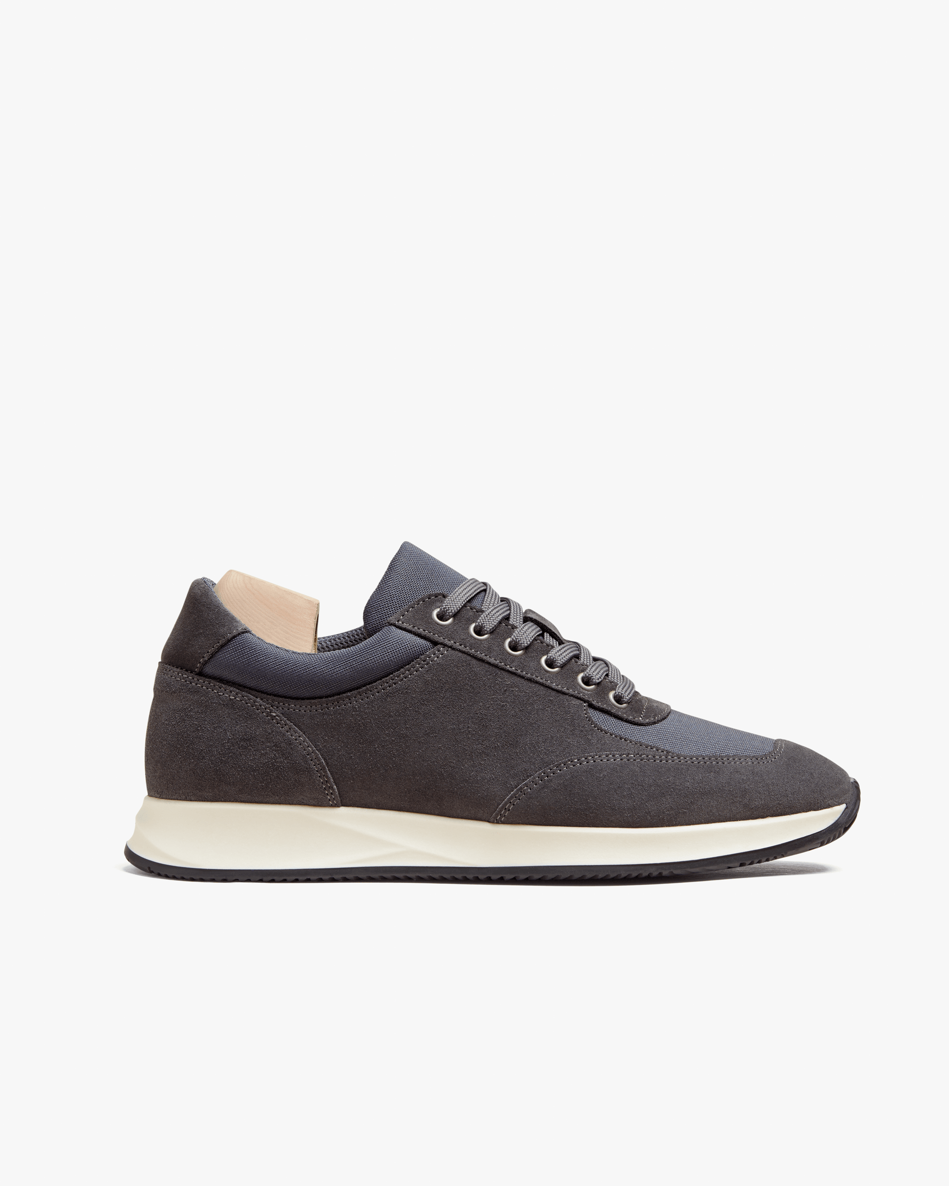 A close-up of Stensund – Dark Grey Suede, detailing the side profile, mesh panels, and contrasting white rubber sole.