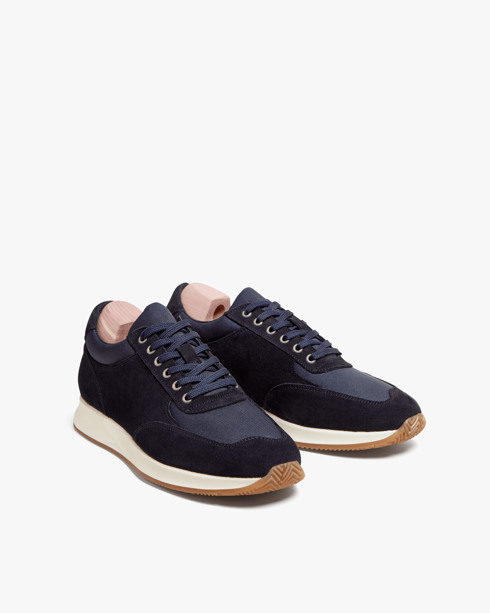 A pair of Stensund – Navy Suede trainers with shoe trees, photographed from a three-quarter angle on a white background.