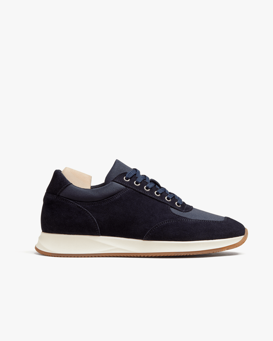 A side profile of Stensund – Navy Suede trainer, showing the navy suede and mesh upper set on a white midsole and gum sole.