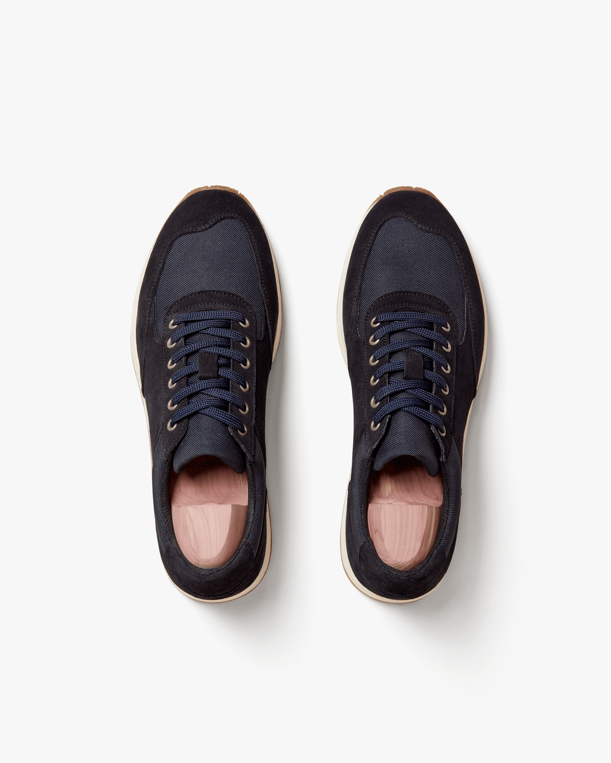 A top-down view of a pair of Stensund – Navy Suede trainers, fitted with shoe trees, on a clean white background.