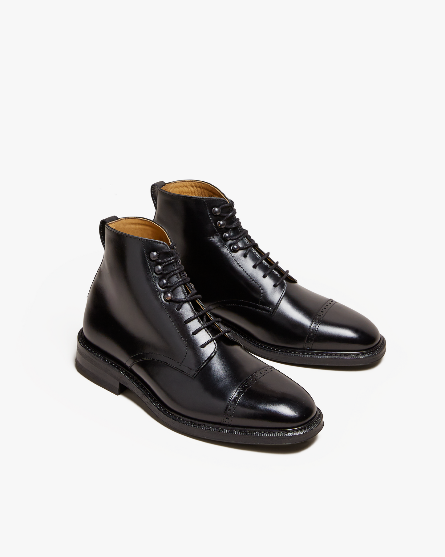 A studio shot of Tjärnö – Black Calf jumper boots, angled to highlight the punched detailing on the toe cap.