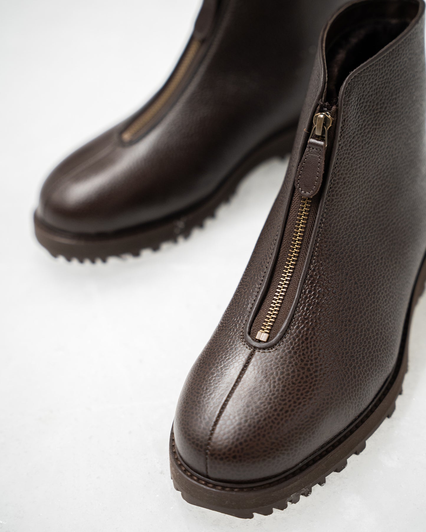 Close-up of Funäs boots in dark brown country calf, highlighting the textured leather, central zip fastening, and rugged sole ideal for winter conditions.