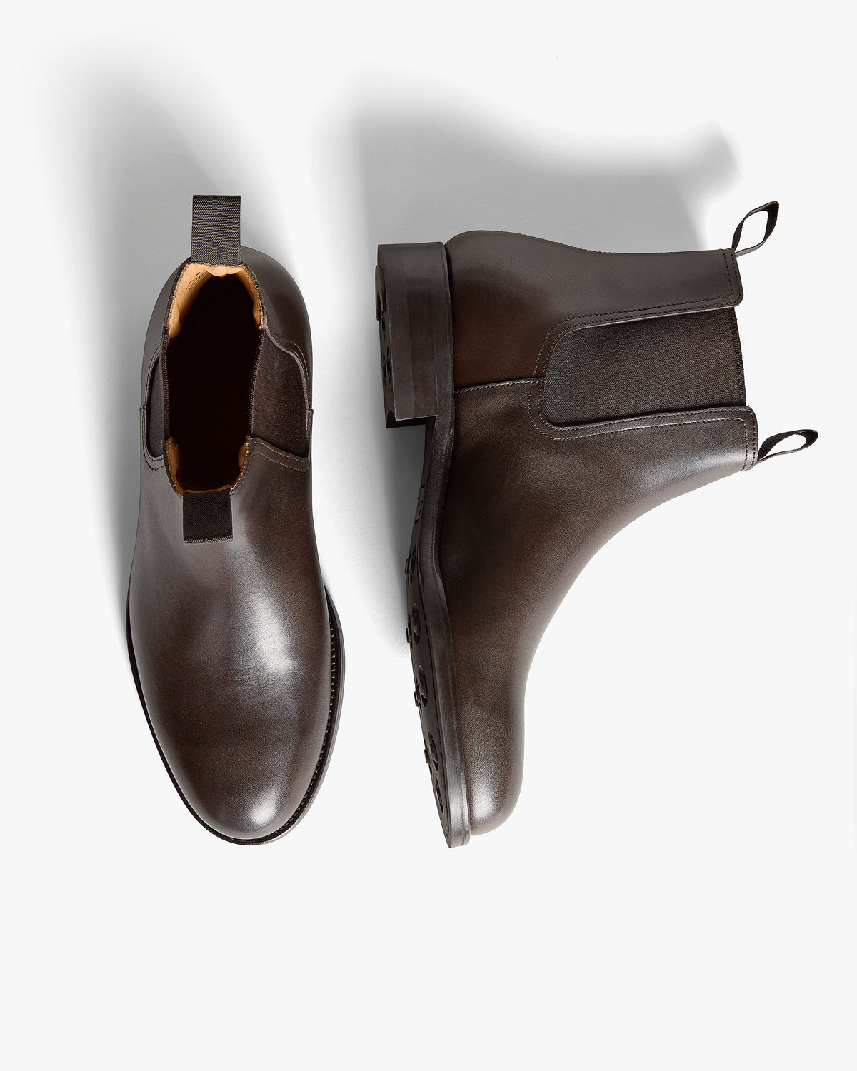 Elfvik II – Dark Brown Calf boots shown with one shoe viewed from above and one resting on its side displaying the sole.