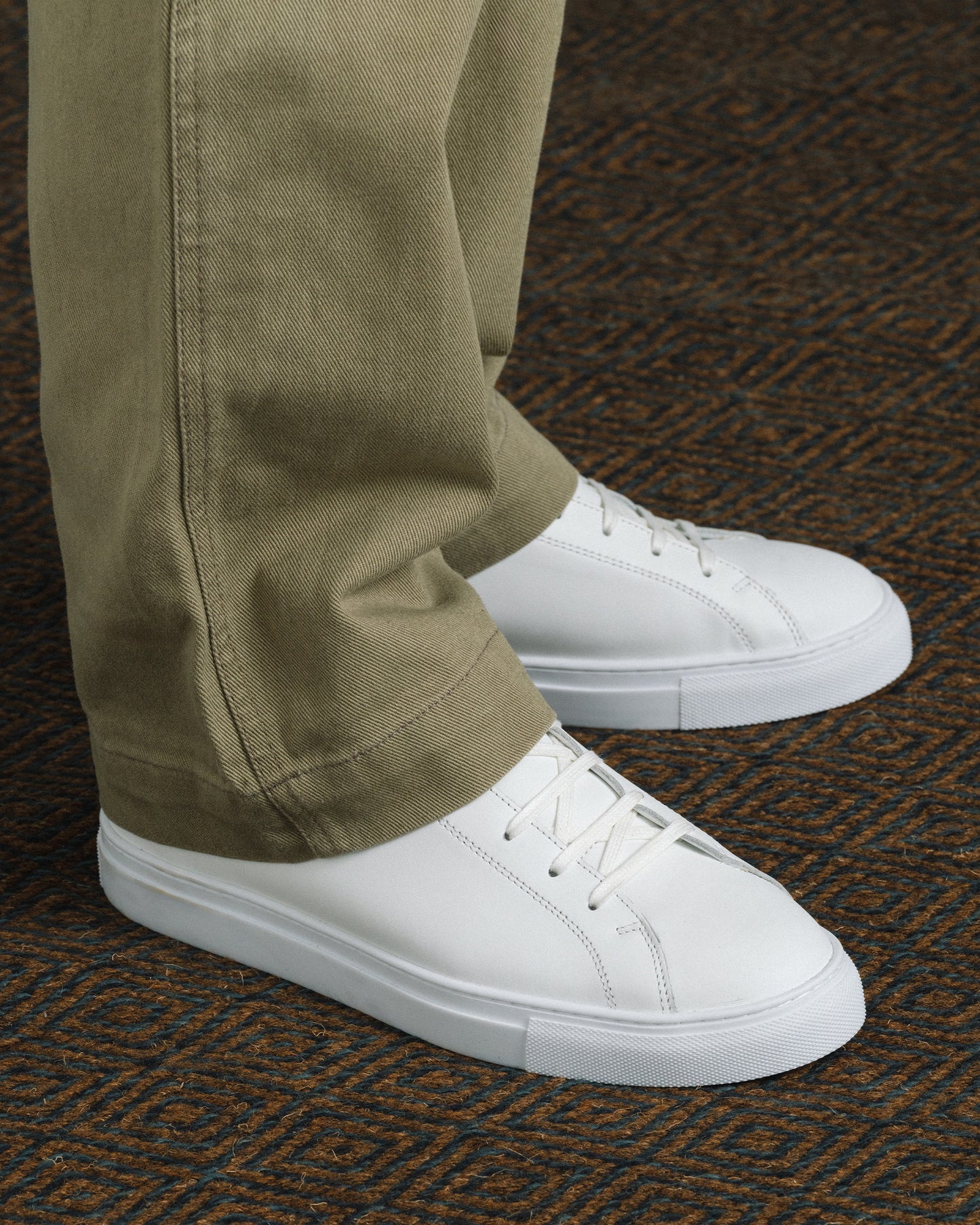 Oaxen in white calf styled with khaki slacks, highlighting the minimalist white leather upper, tonal laces, and clean stitching for a refined, modern look suitable for both casual and smart occasions.