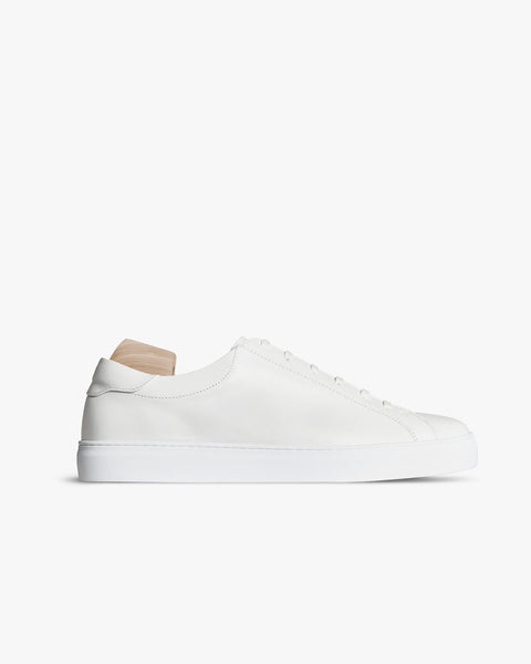 Oaxen – White Calf sneaker in smooth white leather shown in side profile with a wooden shoe tree against a white background.