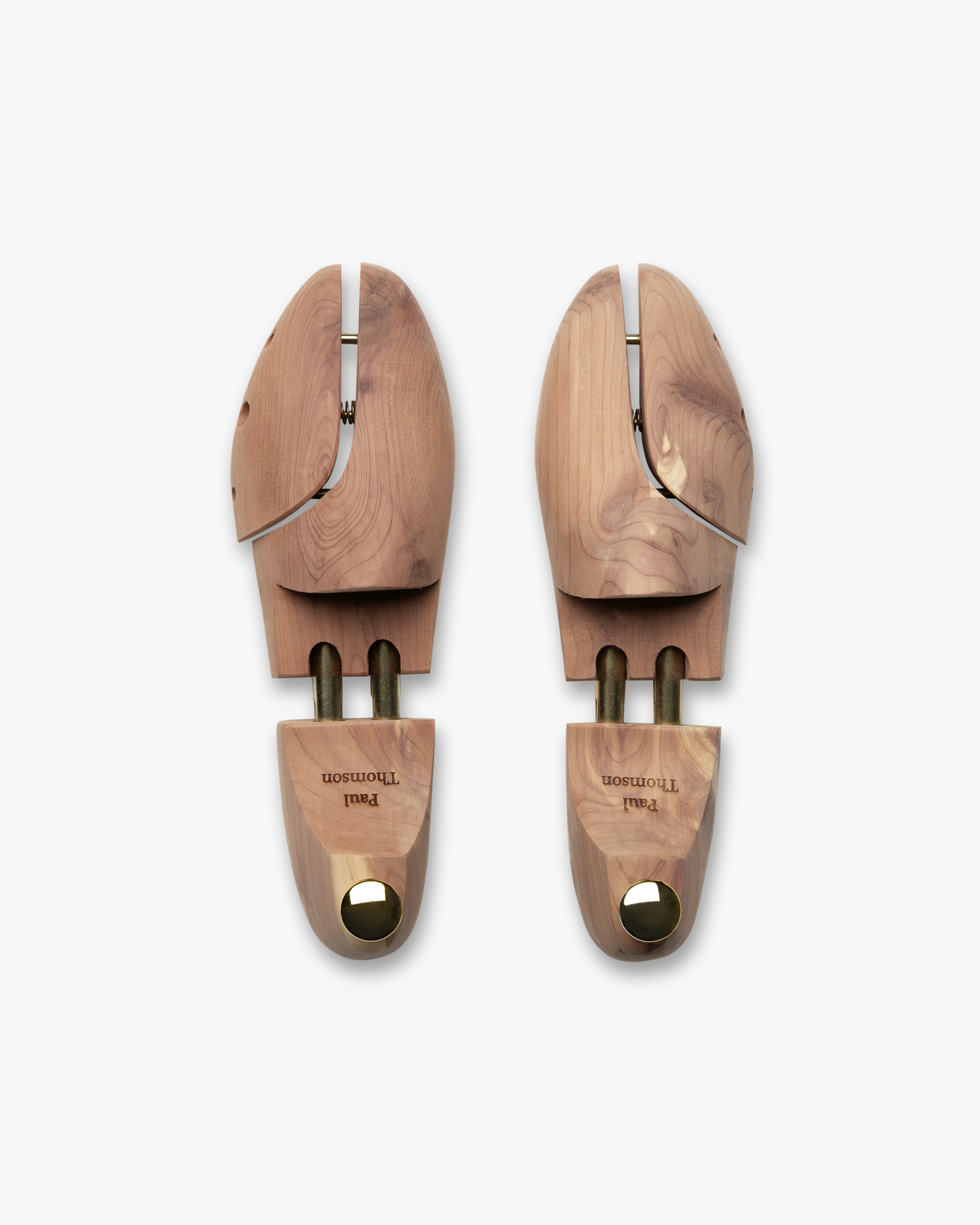 A pair of engraved cedar shoe trees, personalized with the name 'Paul Thomson', shown in a top-down view.