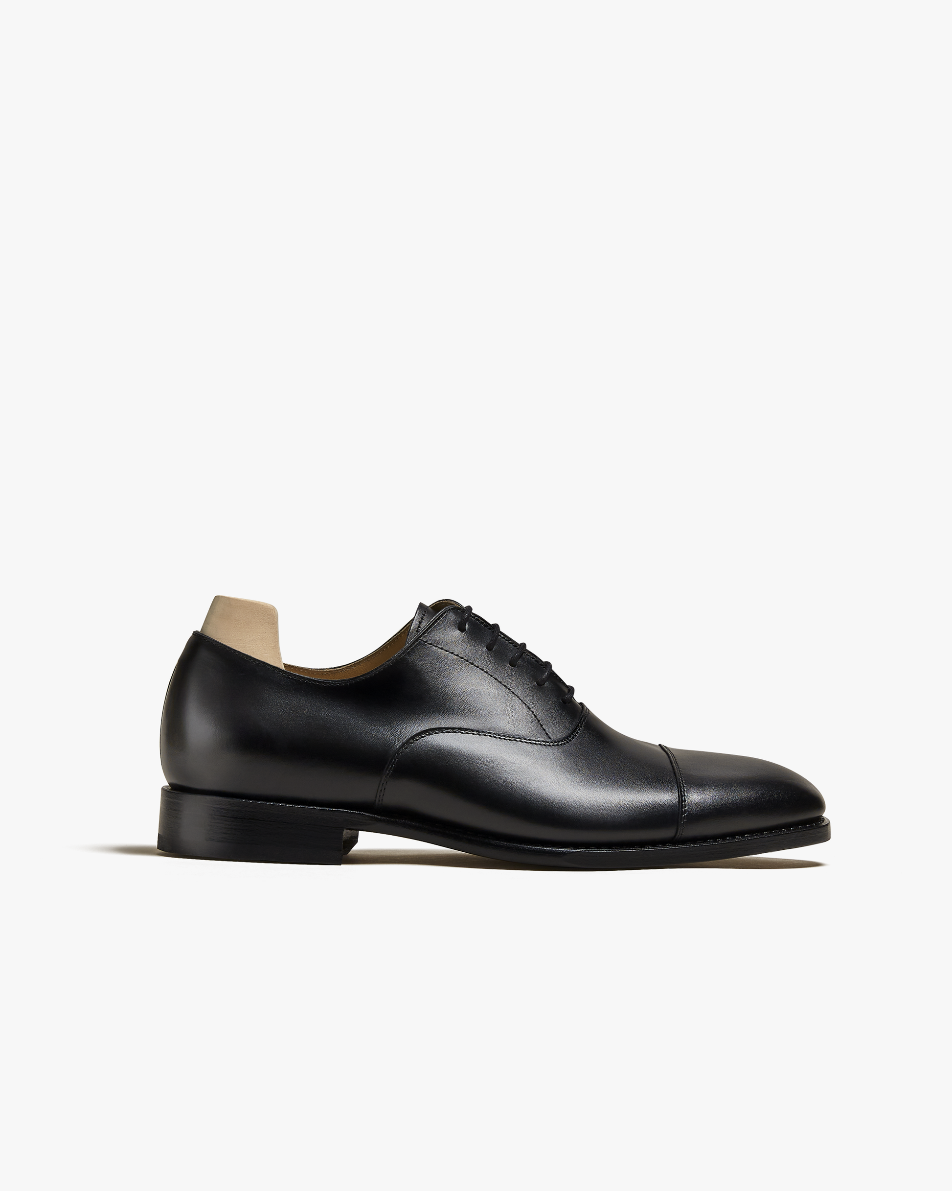Side profile of Äppelviken – Black Calf, a black leather oxford, detailing its elegant silhouette and plain cap toe.
